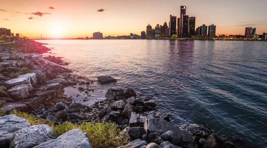 Michigan cityscape showing the Detroit skyline along the Detroit River at sunset, highlighting the state’s urban waterfront.