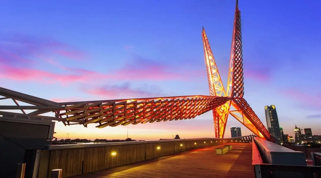 Oklahoma City skyline scene featuring the Skydance Bridge at sunset, highlighting the state’s modern urban landscape.