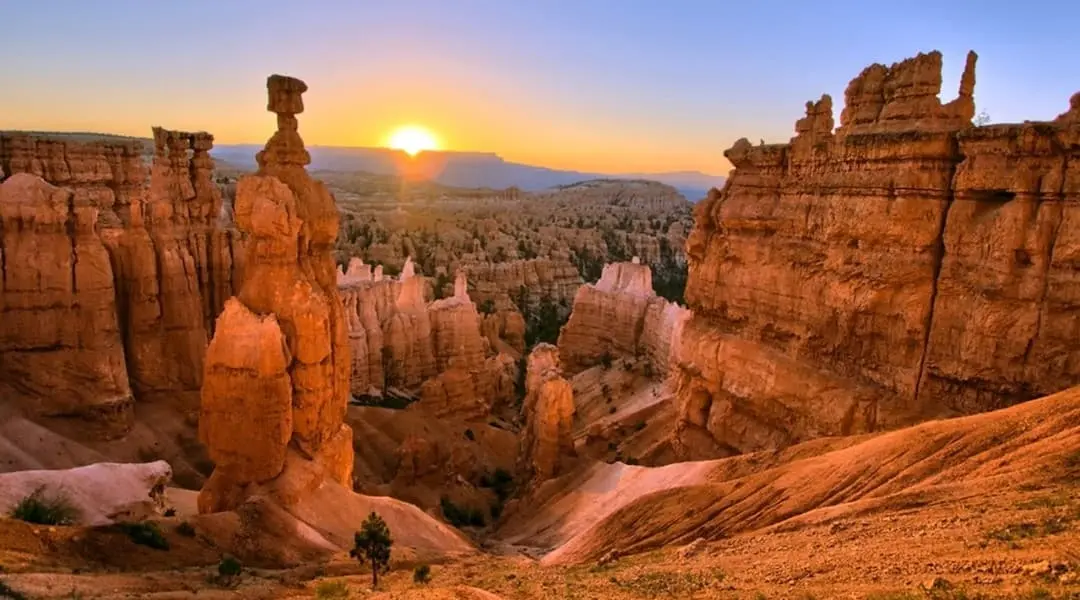 Utah landscape at sunrise featuring Bryce Canyon hoodoos and sandstone cliffs, highlighting the state’s iconic desert scenery.