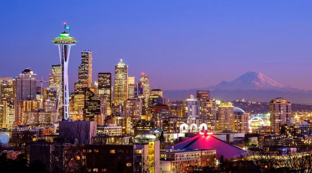 Seattle, Washington skyline at dusk with the Space Needle and Mount Rainier in the background, highlighting the state’s iconic urban landscape.