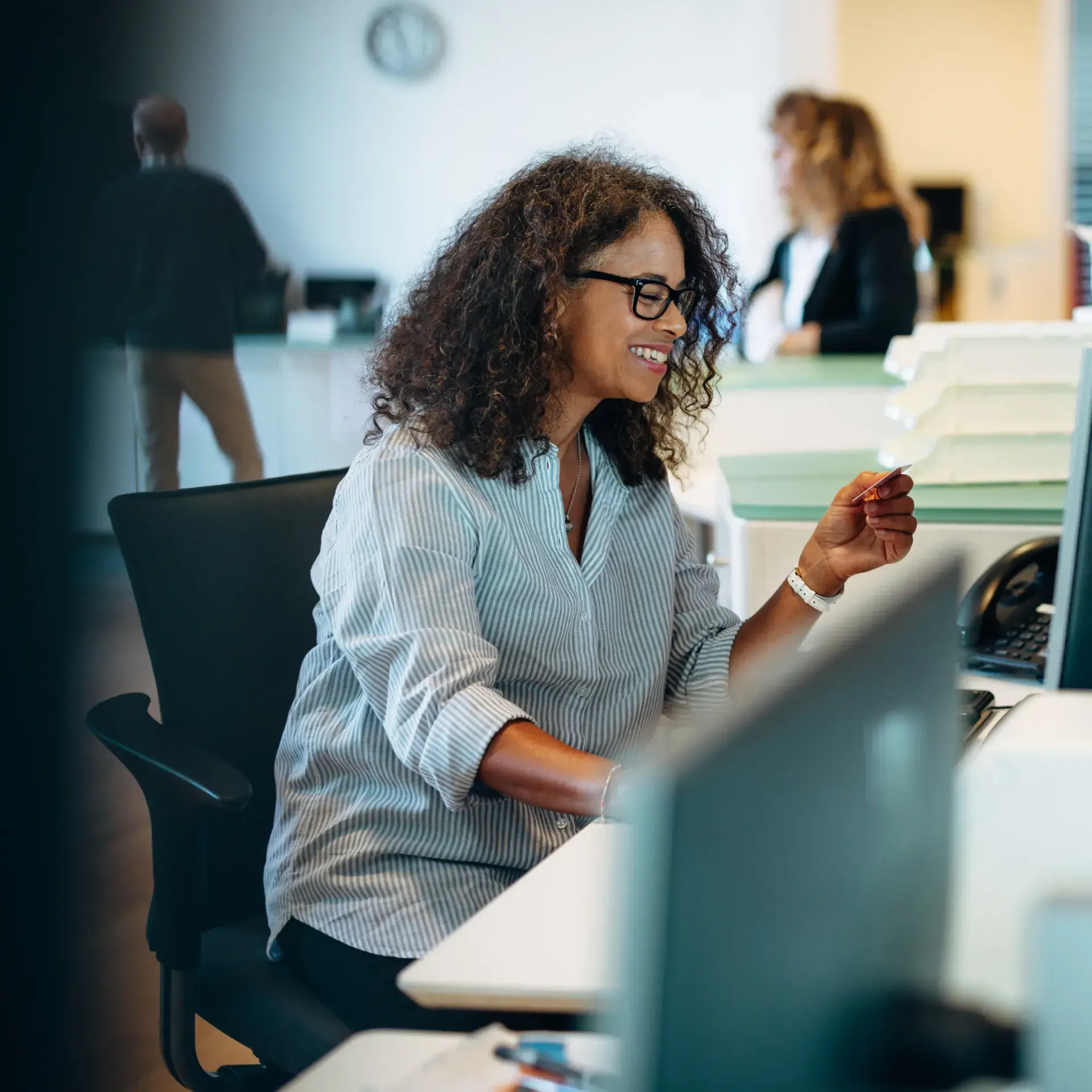 A woman sitting at a desk in front of a computer.