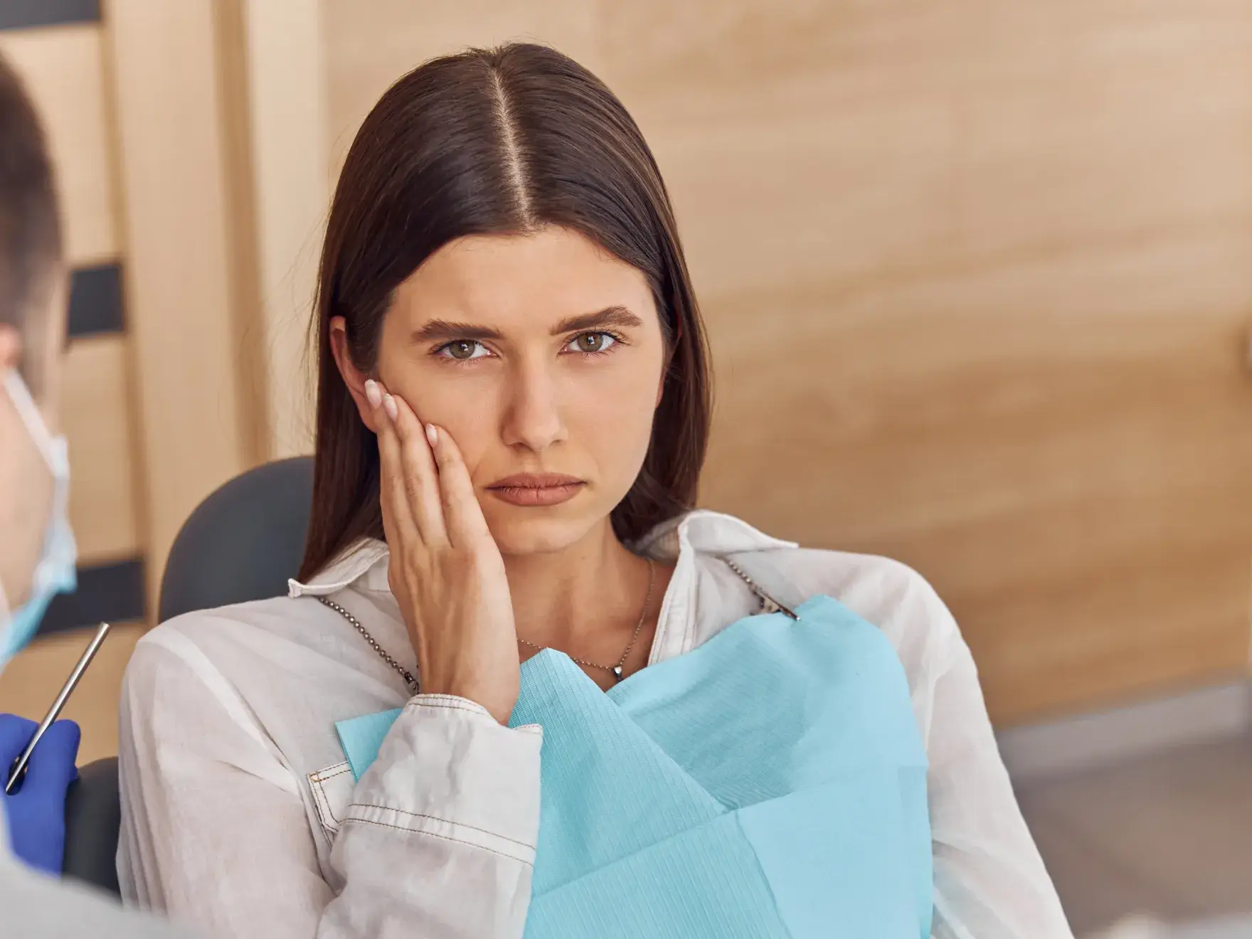 A woman with a toothbrush in her hand and a man in a medical mask.