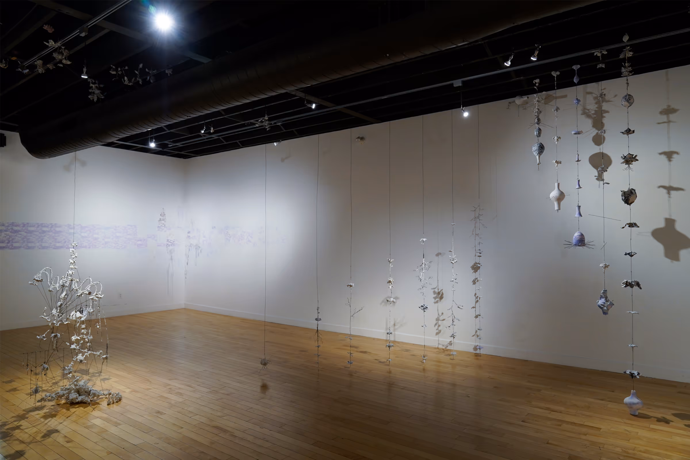 Still lives in transition (Nostalgia without memory III), 2024, Rebar tie-wire, joint compound, printer paper, ink, and inkjet transfers, 44 x 21 x 12 feet