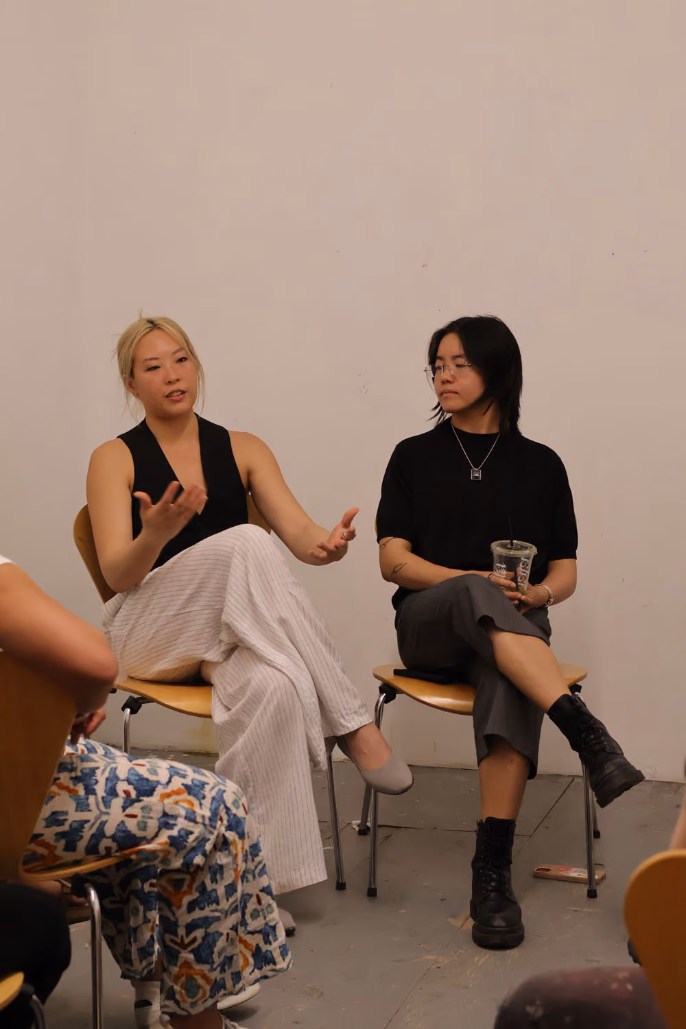 Screening: Erika Choe and Colby Lamson-Gordon: two women sit on chairs talking, one gesturing, with an audience member partly visible in the foreground.