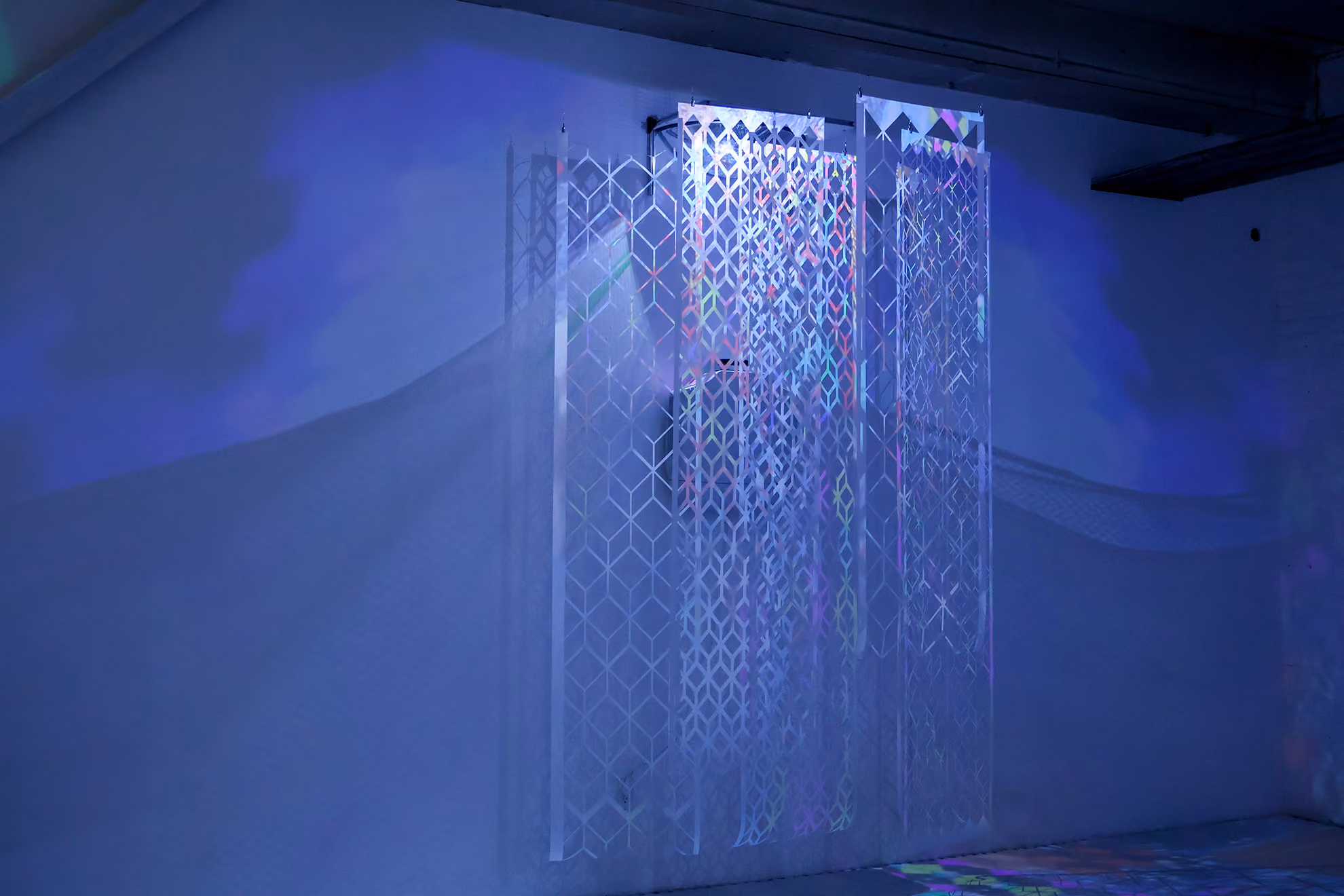 NARS Spring Open Studios 2026: translucent acrylic panels with a lattice pattern stand in a dim room lit in blue and violet.
