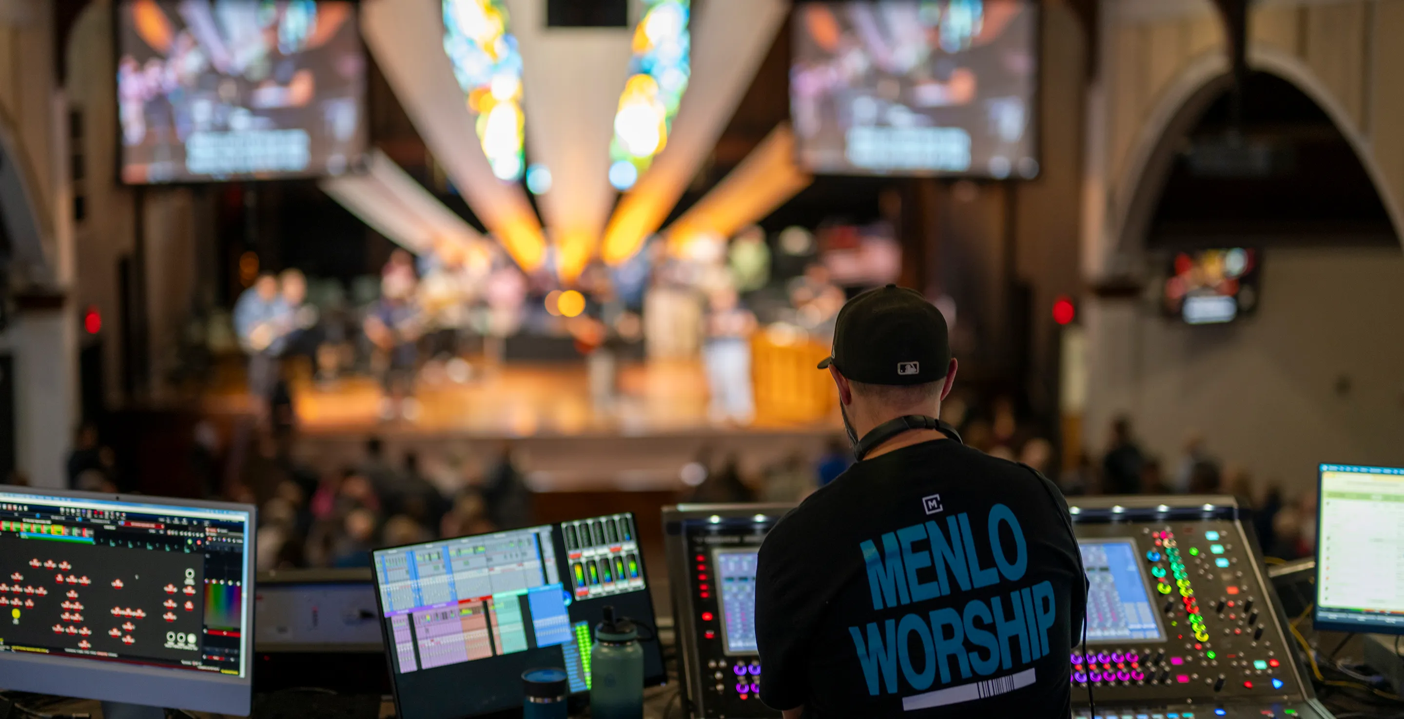 Sound technician at mixing console managing audio during a live church worship service.