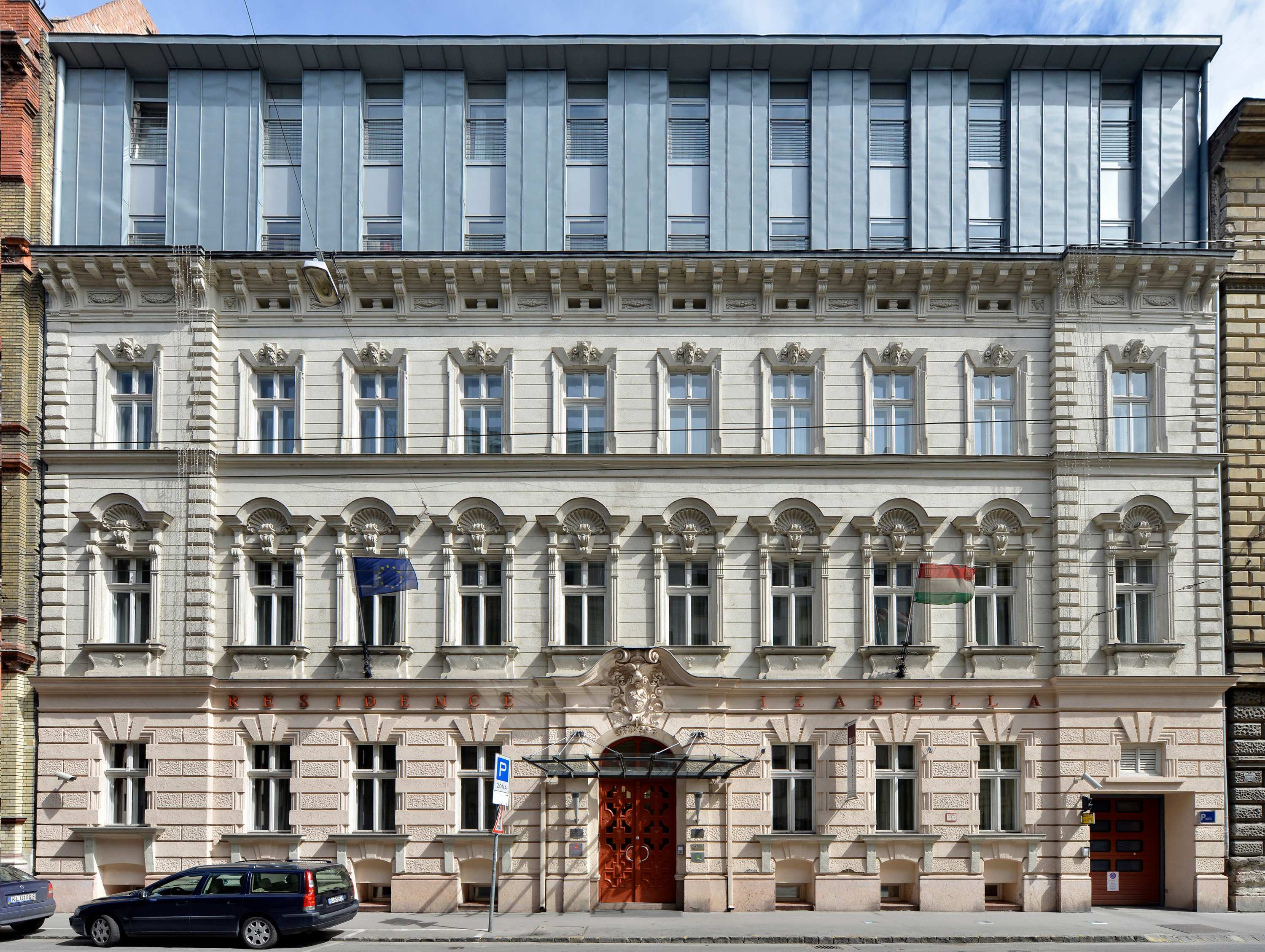 Residence Izabella is a distinguished 4-star long-term hotel located in central Budapest. Designed by Sándor Dúzs / ArkTOON Architects (predecessor of MSK Architects) in collaboration with Schön Architects, the project transforms a historic urban building into a contemporary hospitality residence. The design preserves the original street façade while introducing a refined rooftop addition and reorganized internal courtyard. It offers 38 light-filled suites, creating a unique blend of historic character and modern comfort in the heart of Budapest. 