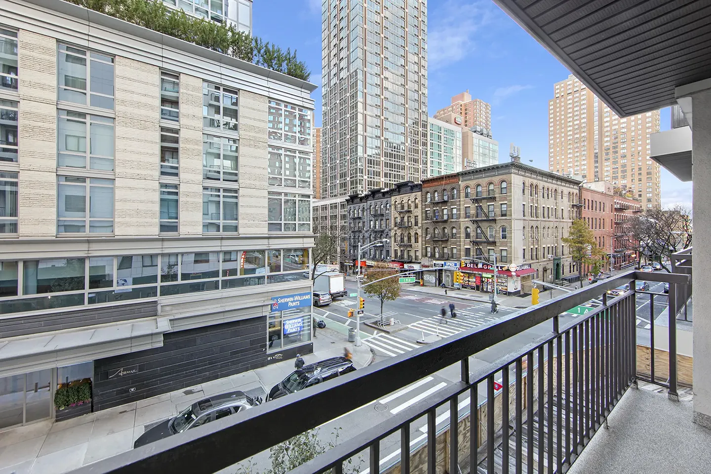 A balcony overlooking a city skyline filled with various buildings under a clear blue sky.