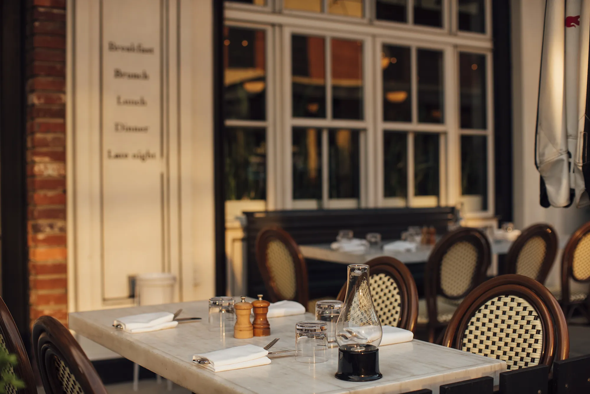 A table covered with a crisp white cloth, elegantly set for a meal.