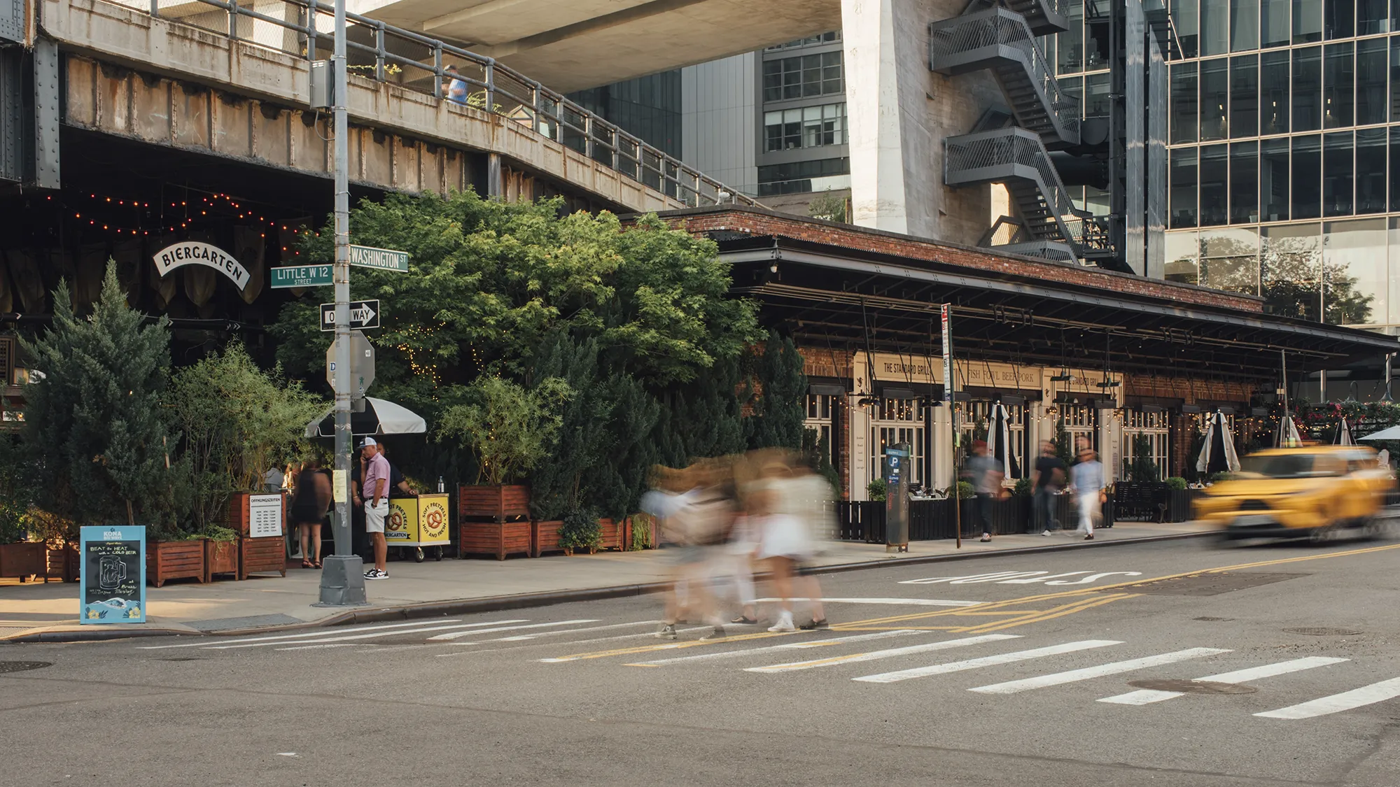 A yellow taxi cab drives along a city street, surrounded by buildings and other vehicles.