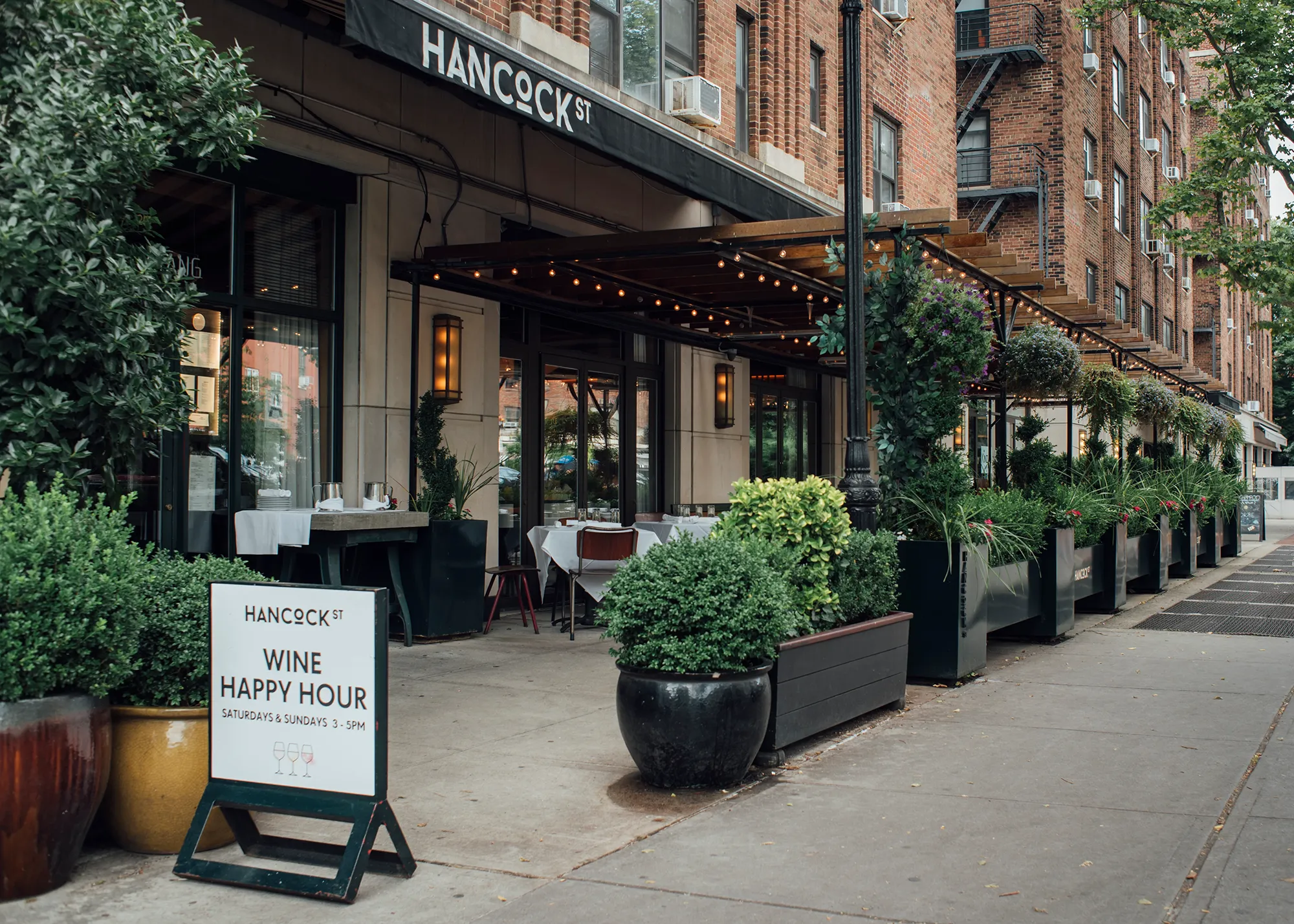 A sidewalk bordered by various green plants, creating a natural and inviting atmosphere for pedestrians.