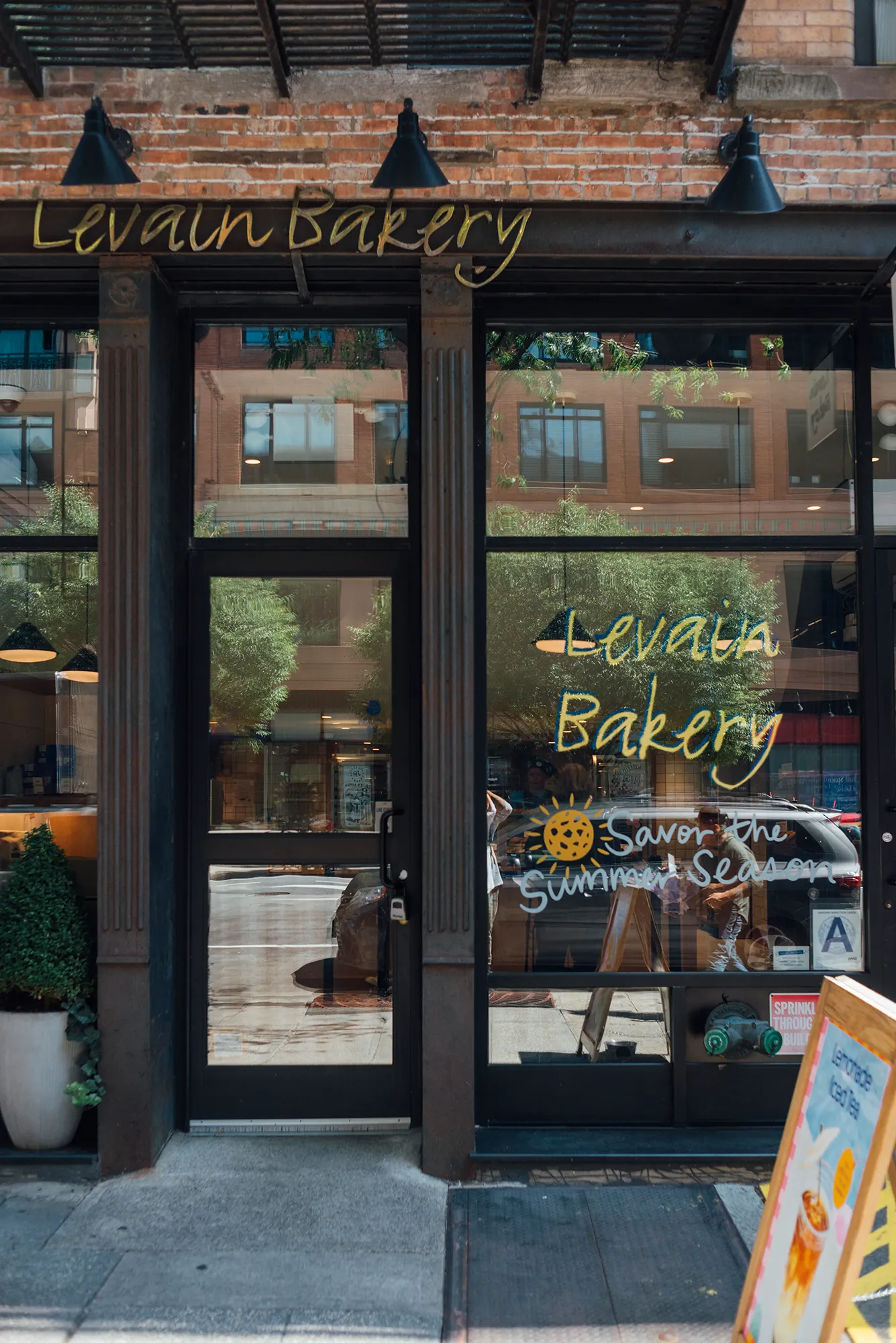 A storefront featuring a sign that reads "Levain Bakery," showcasing a welcoming entrance and baked goods display.