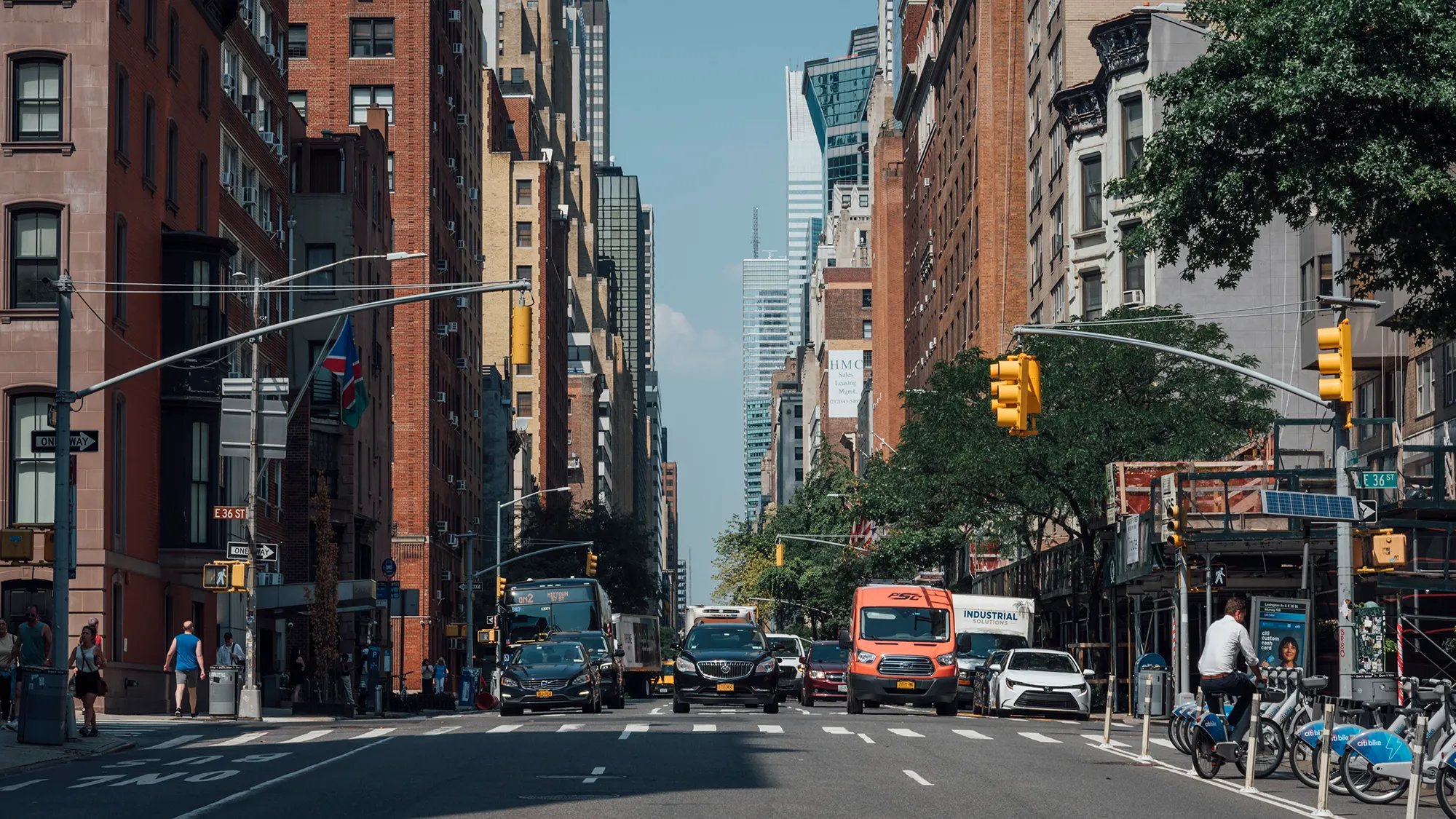 A bustling urban street scene with vehicles and high-rise buildings in the background.