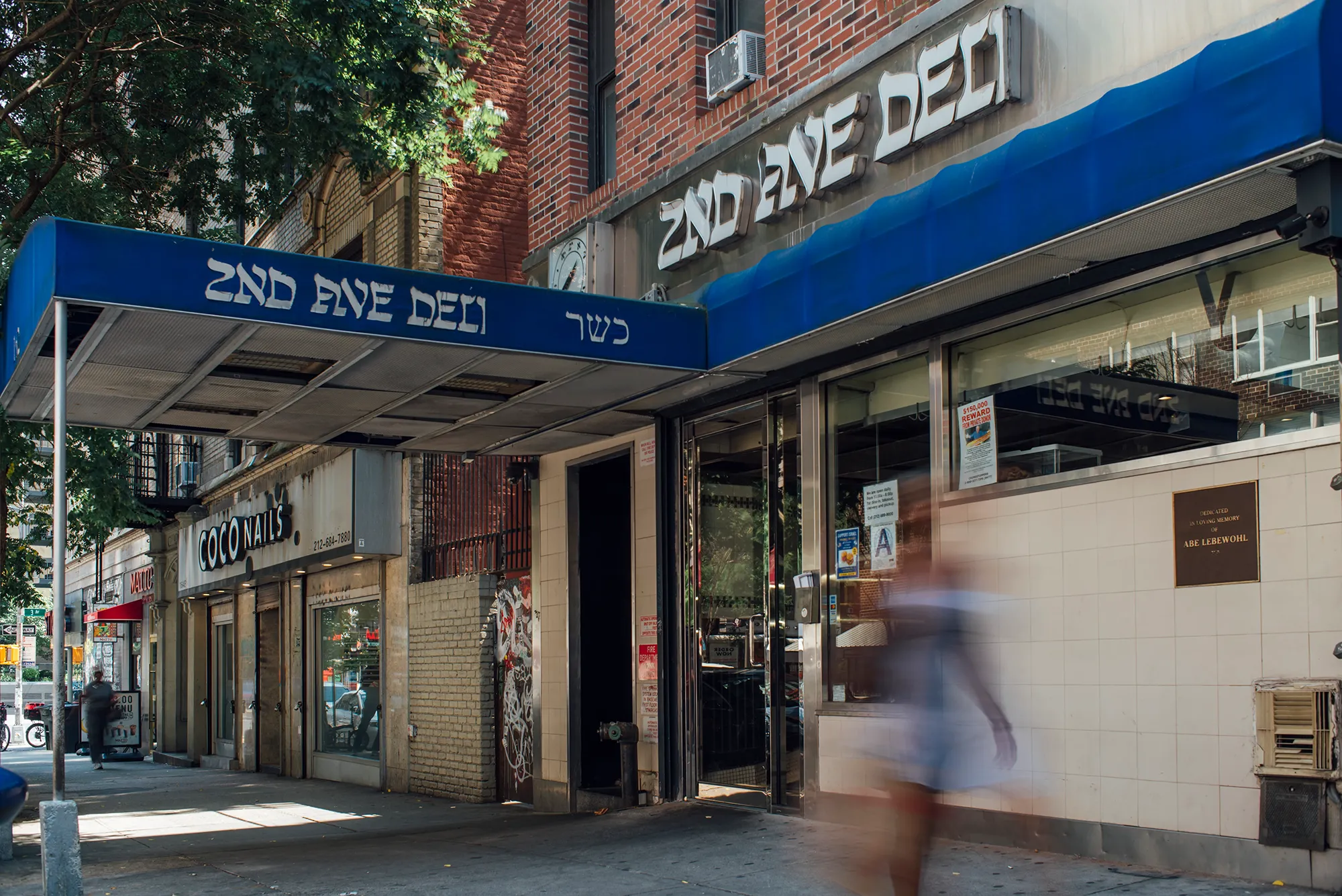 A woman walks down the street, showcasing the vibrant community atmosphere.