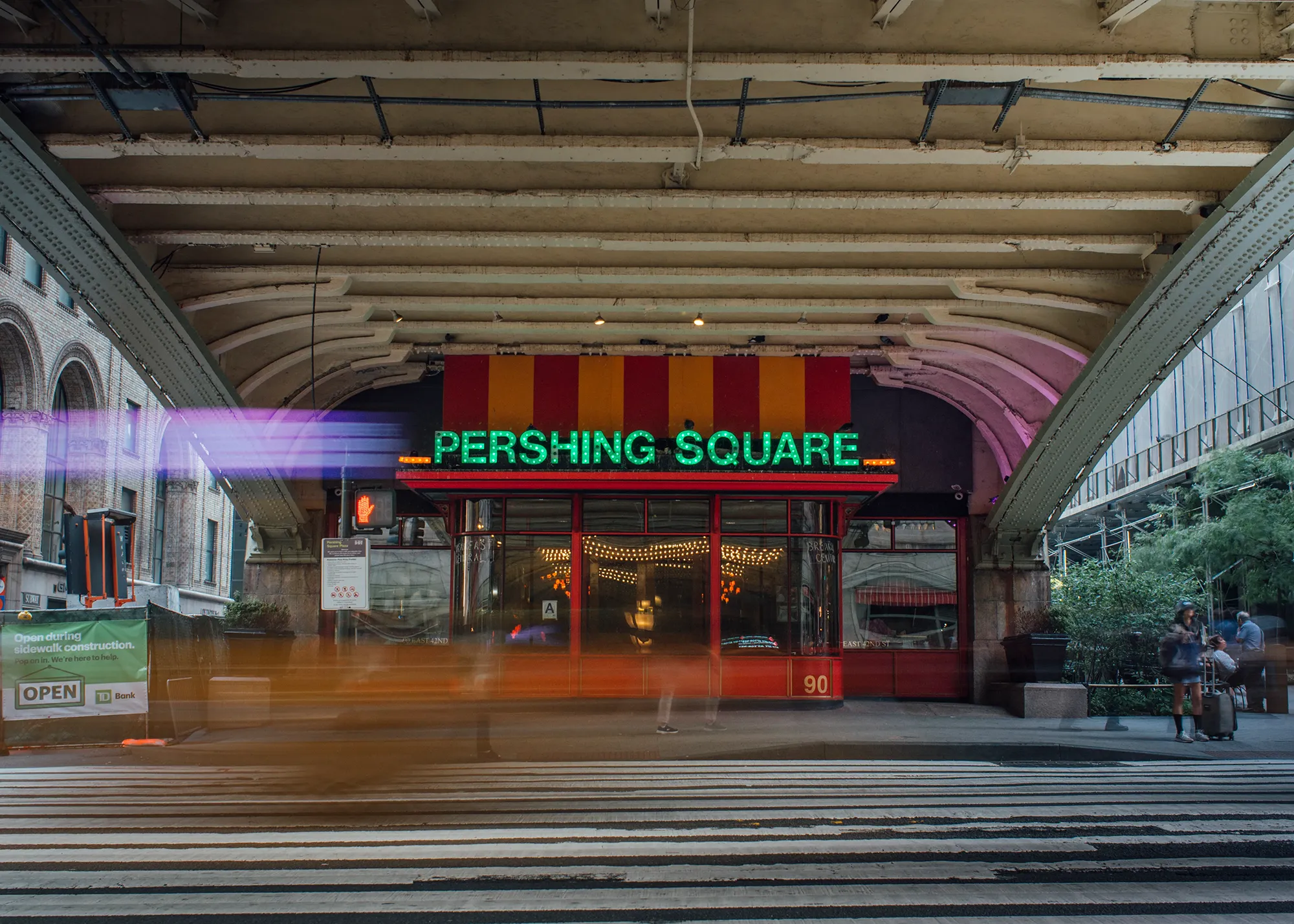 A street scene featuring a building in the background, showcasing urban architecture and a clear sky.
