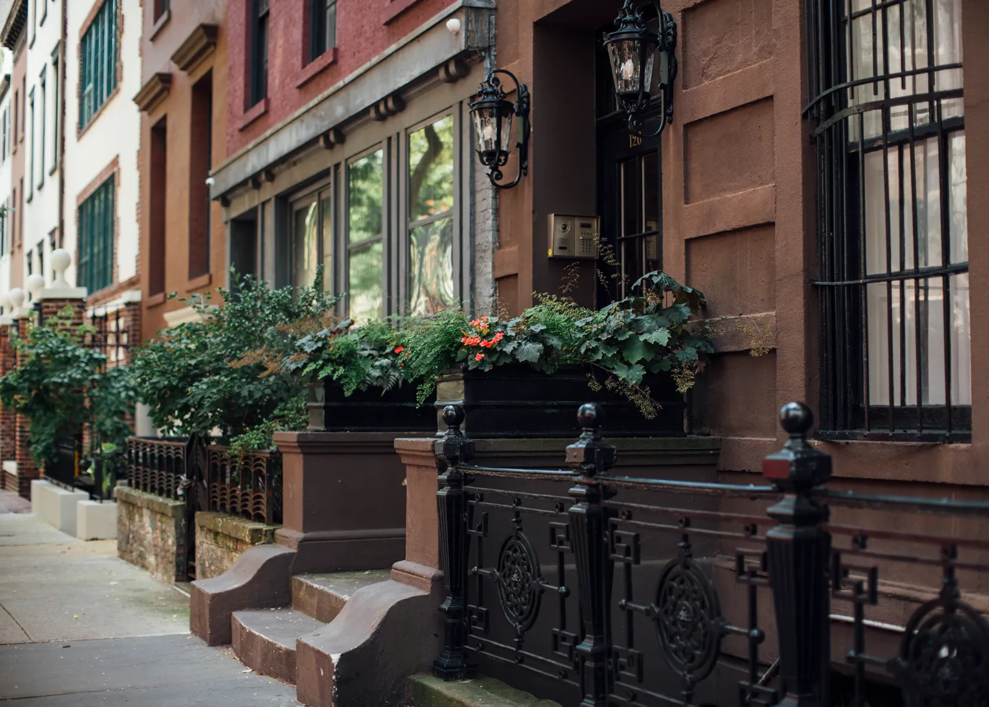 A row of various buildings lined up against a clear blue sky, showcasing different architectural styles.
