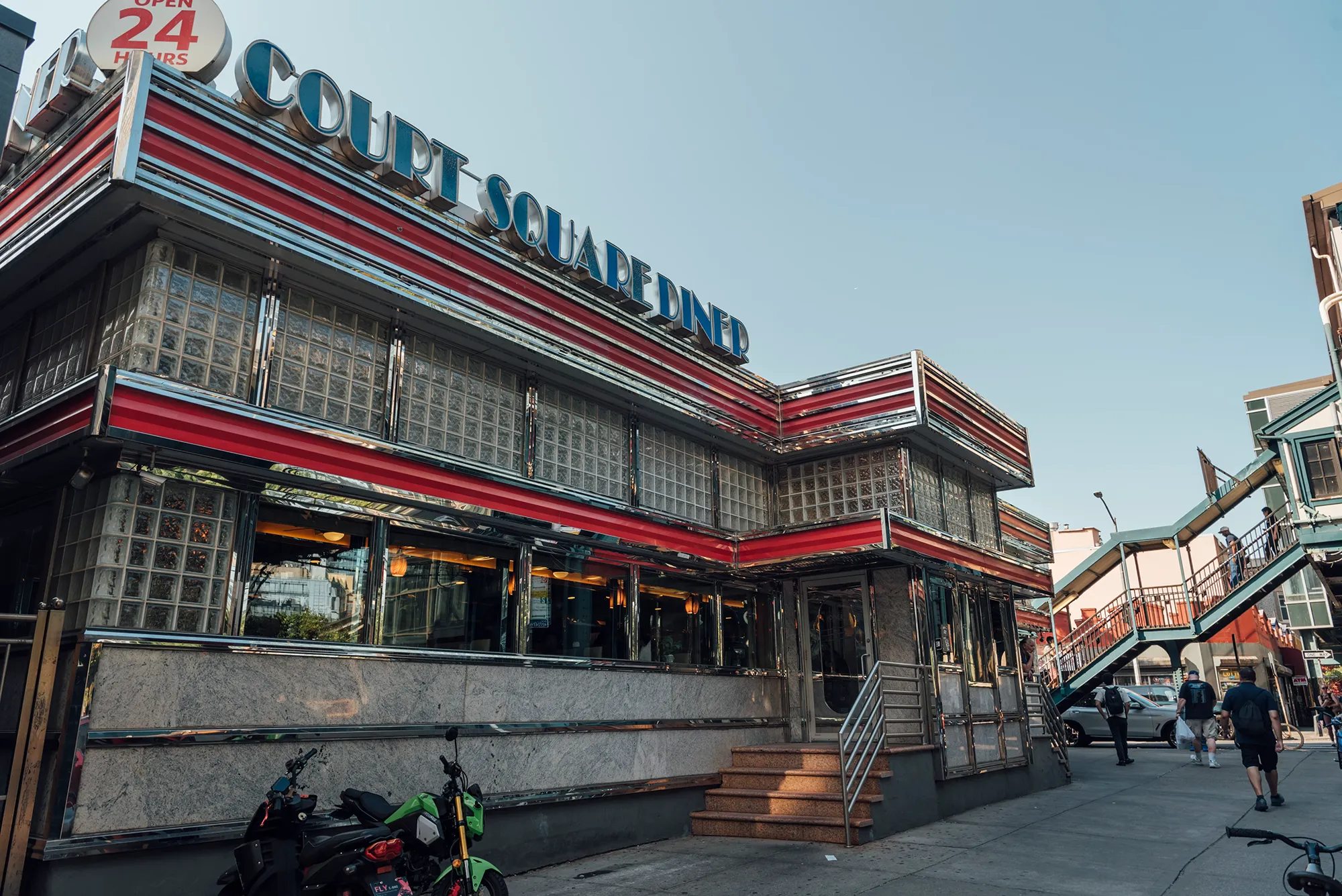 A classic diner exterior with a motorcycle parked in front, showcasing a retro vibe and inviting atmosphere.