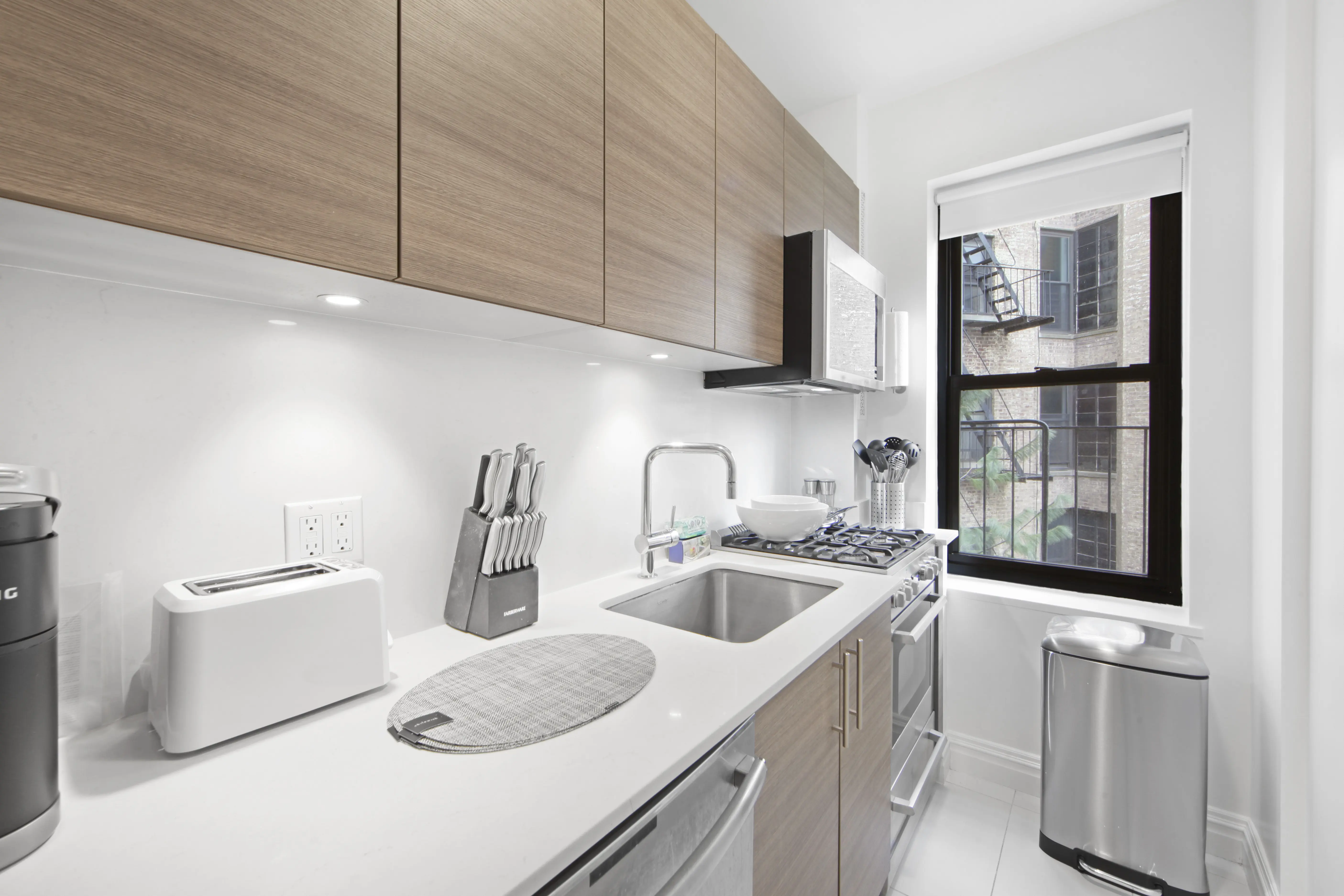 A modern kitchen featuring a sink, dishwasher, and microwave, showcasing a clean and functional design.