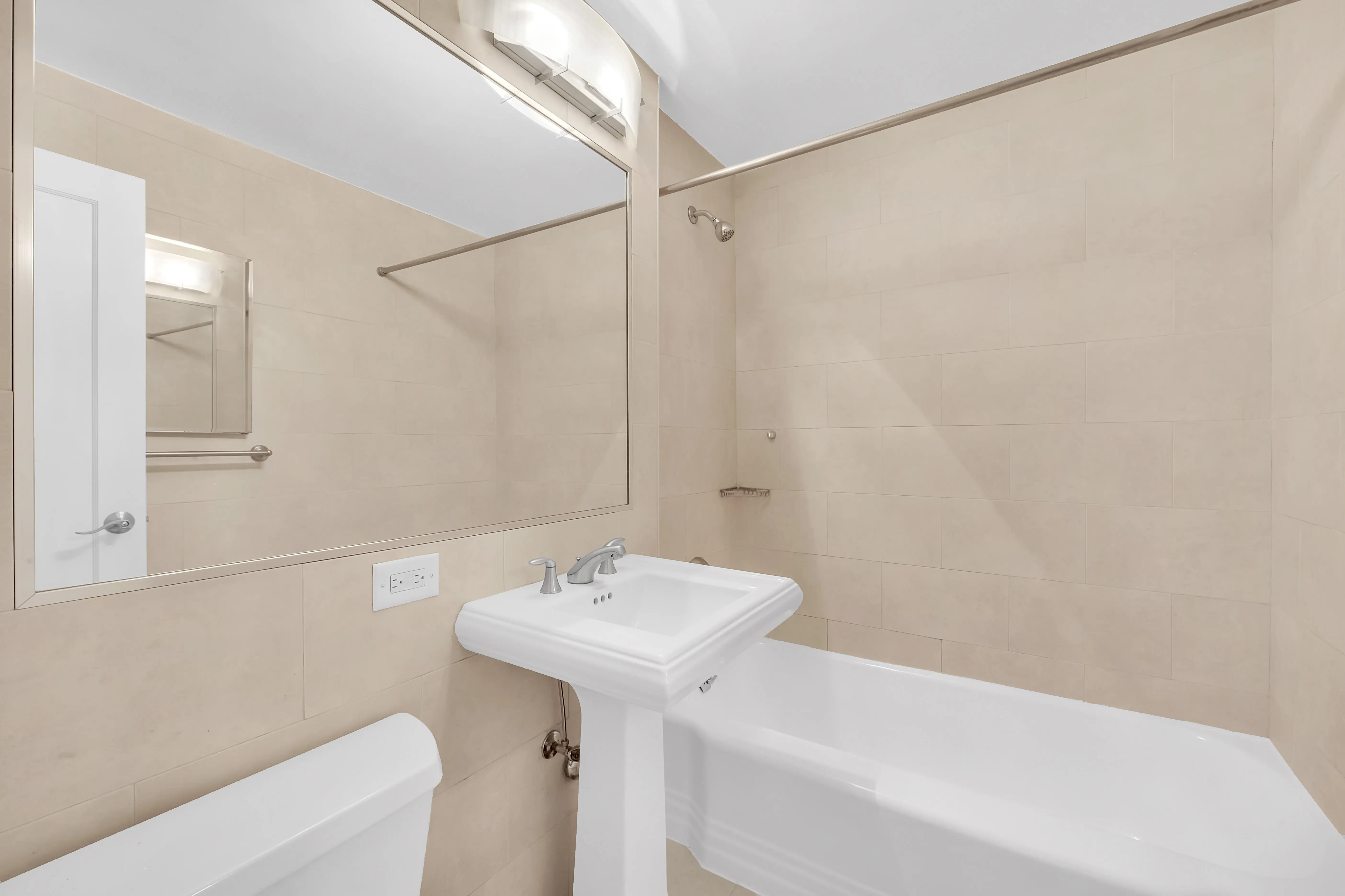 A bathroom featuring a toilet, sink, and bathtub arranged in a clean and modern layout.
