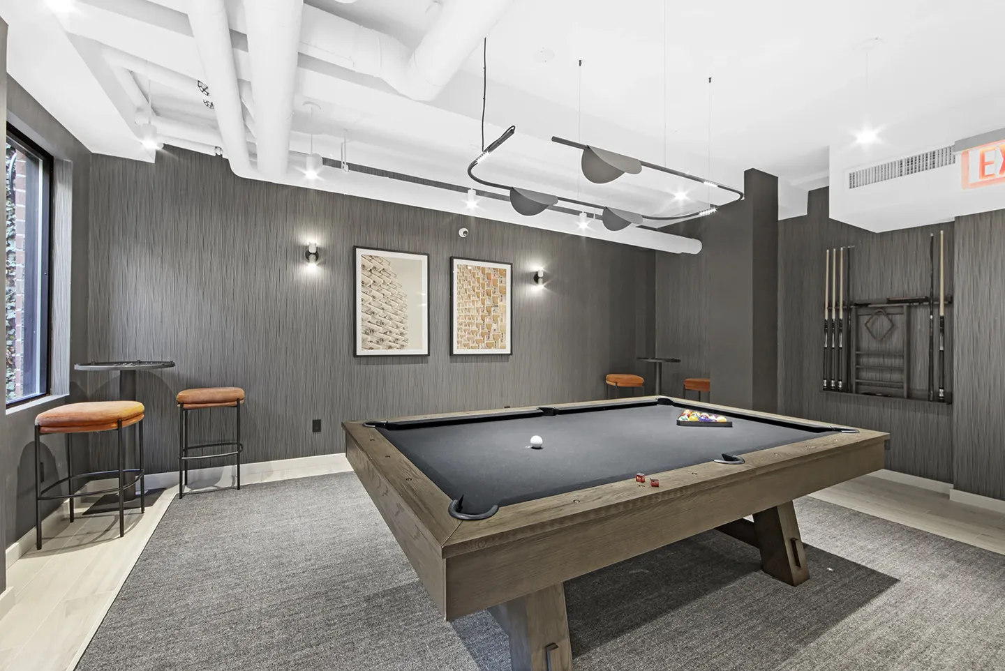 A sleek billiard table set in a contemporary game room within a new apartment, featuring stylish furnishings and decor.
