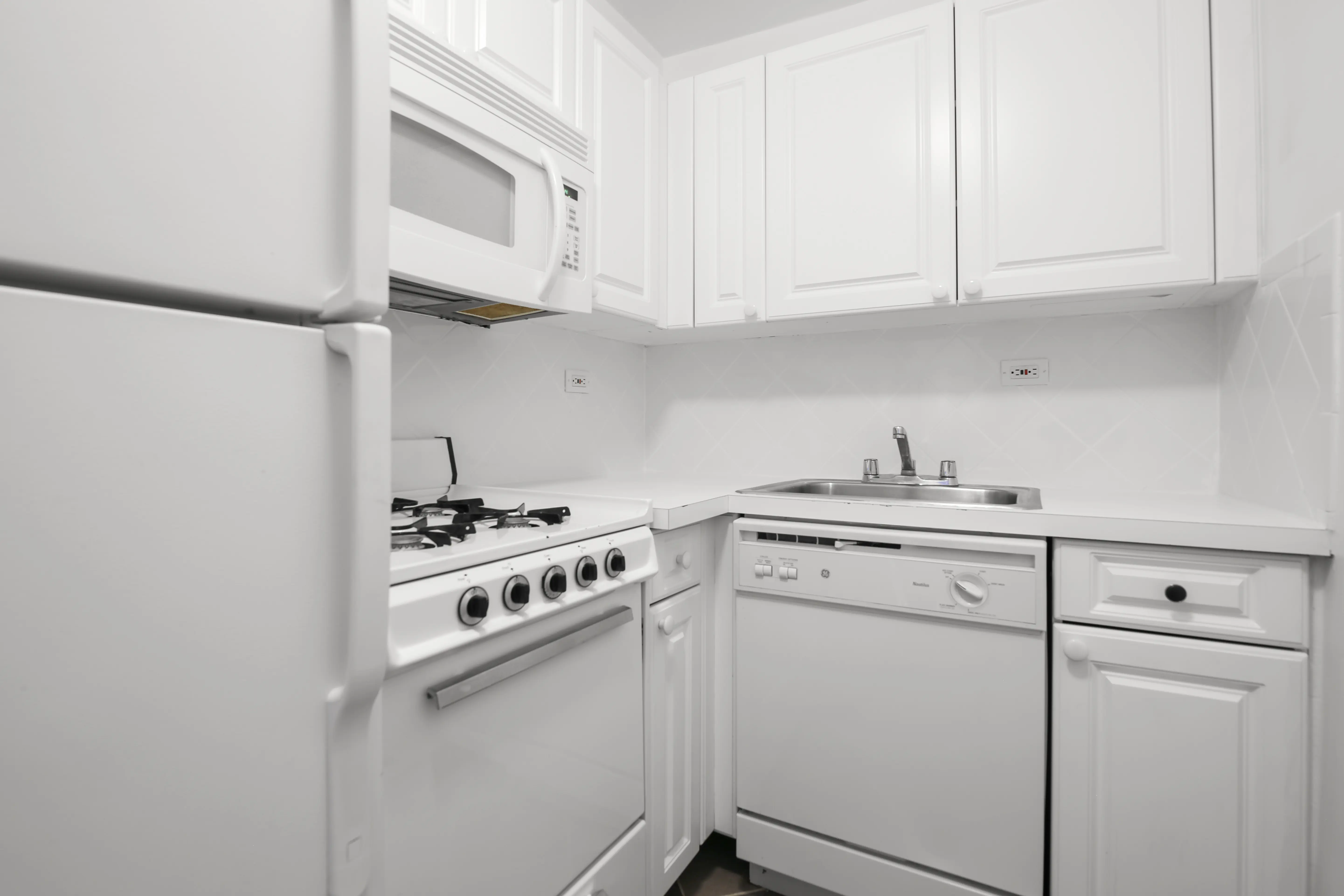A well-organized kitchen showcasing white cabinetry and appliances, highlighting a fresh and inviting atmosphere.