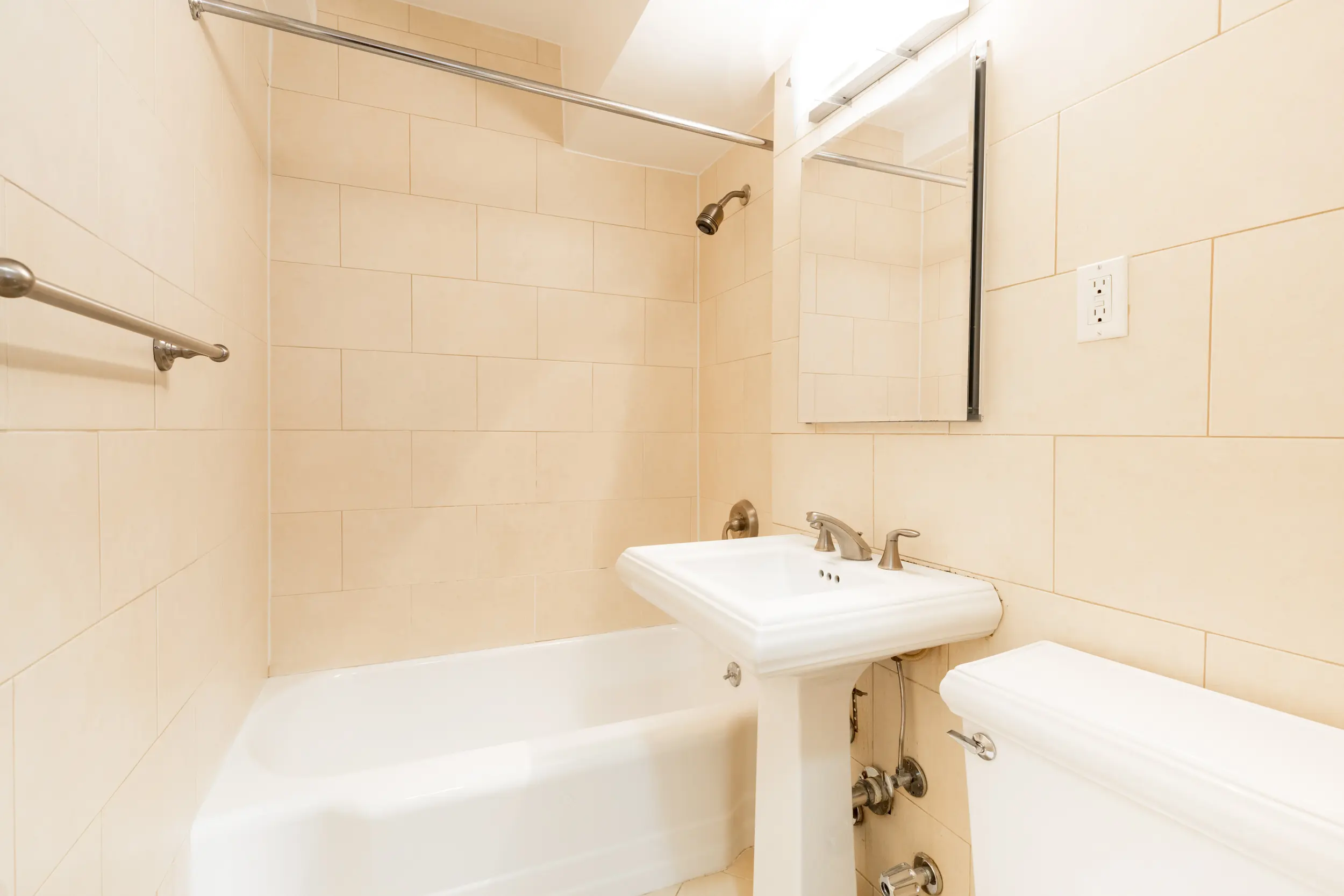 A well-organized bathroom containing a toilet, sink, and shower, highlighted by contemporary fixtures and a fresh ambiance.