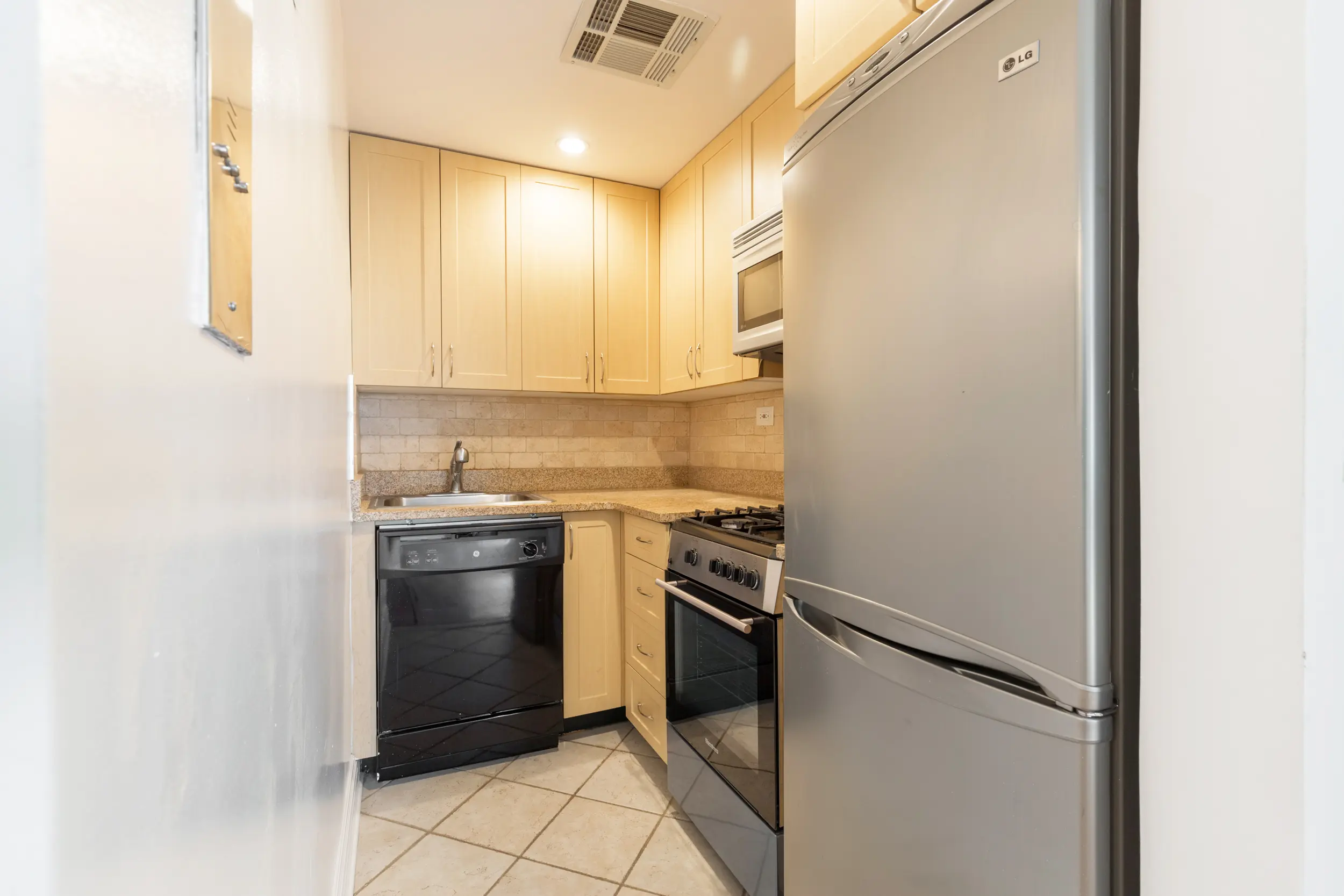 A small kitchen equipped with essential appliances: a refrigerator, stove, and dishwasher for efficient meal preparation.