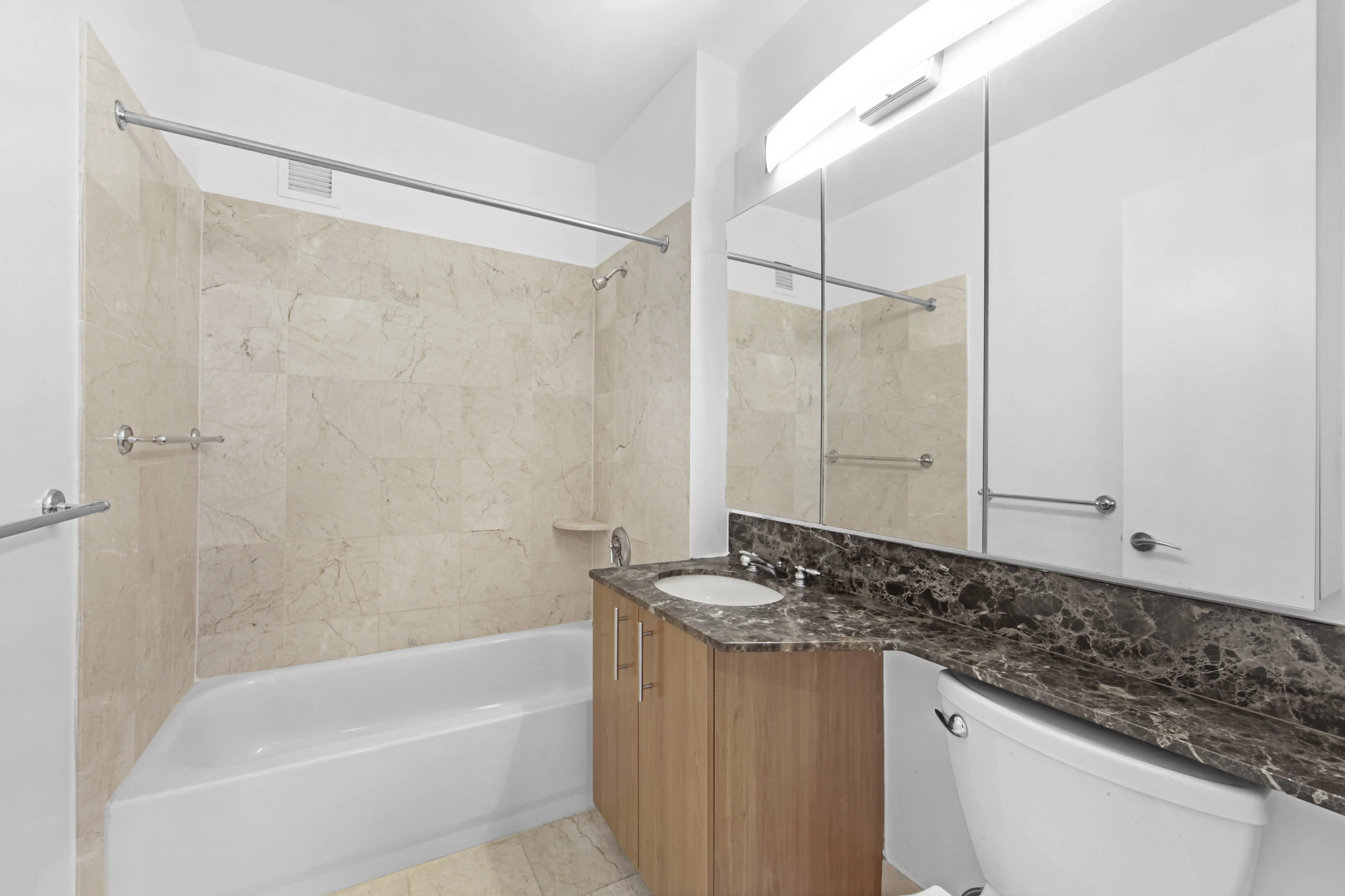 Interior view of a bathroom with a toilet, sink, and shower, showcasing essential fixtures for personal hygiene.