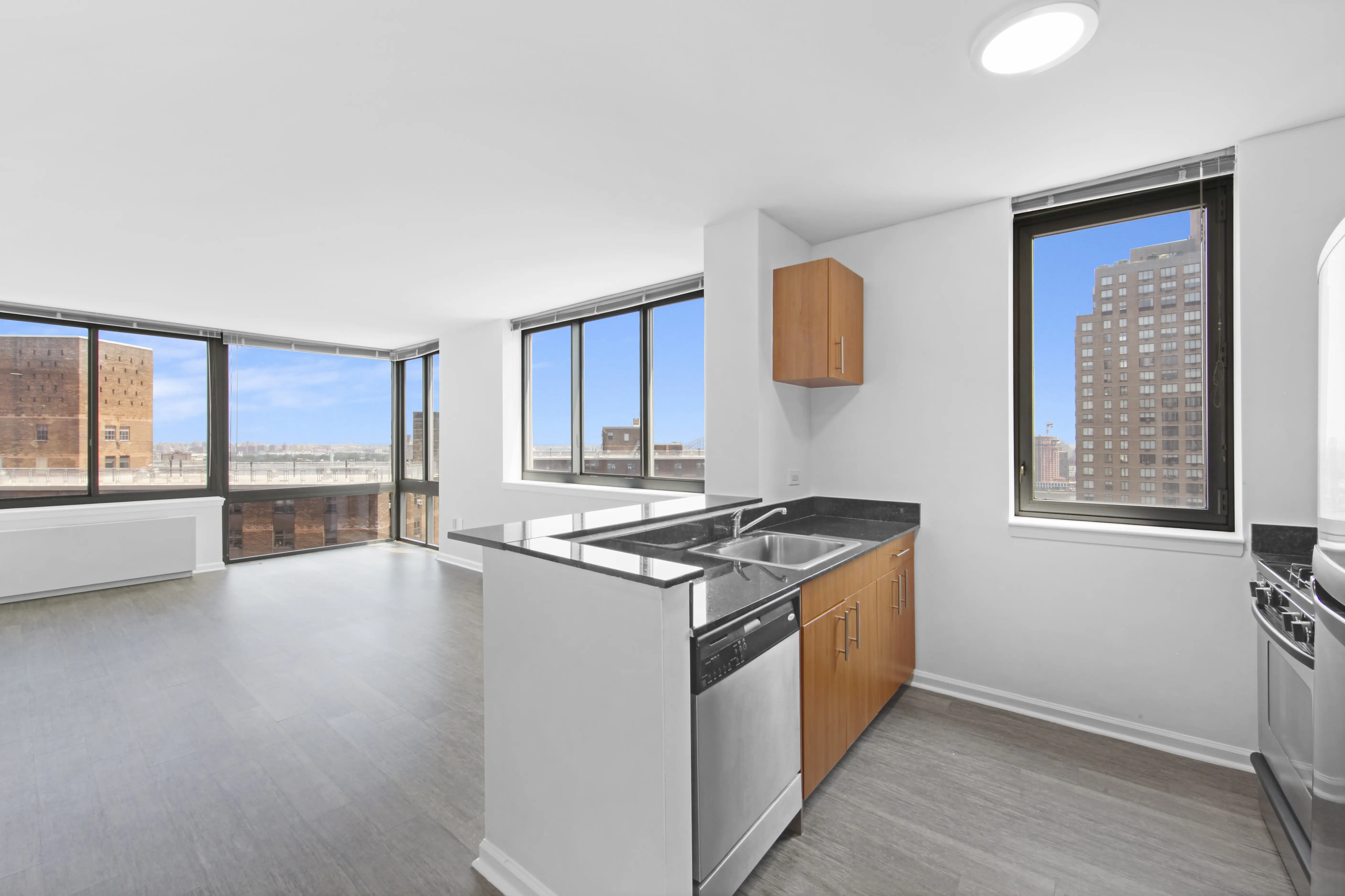A bright kitchen featuring a large window and a stove, creating a warm and inviting cooking space.