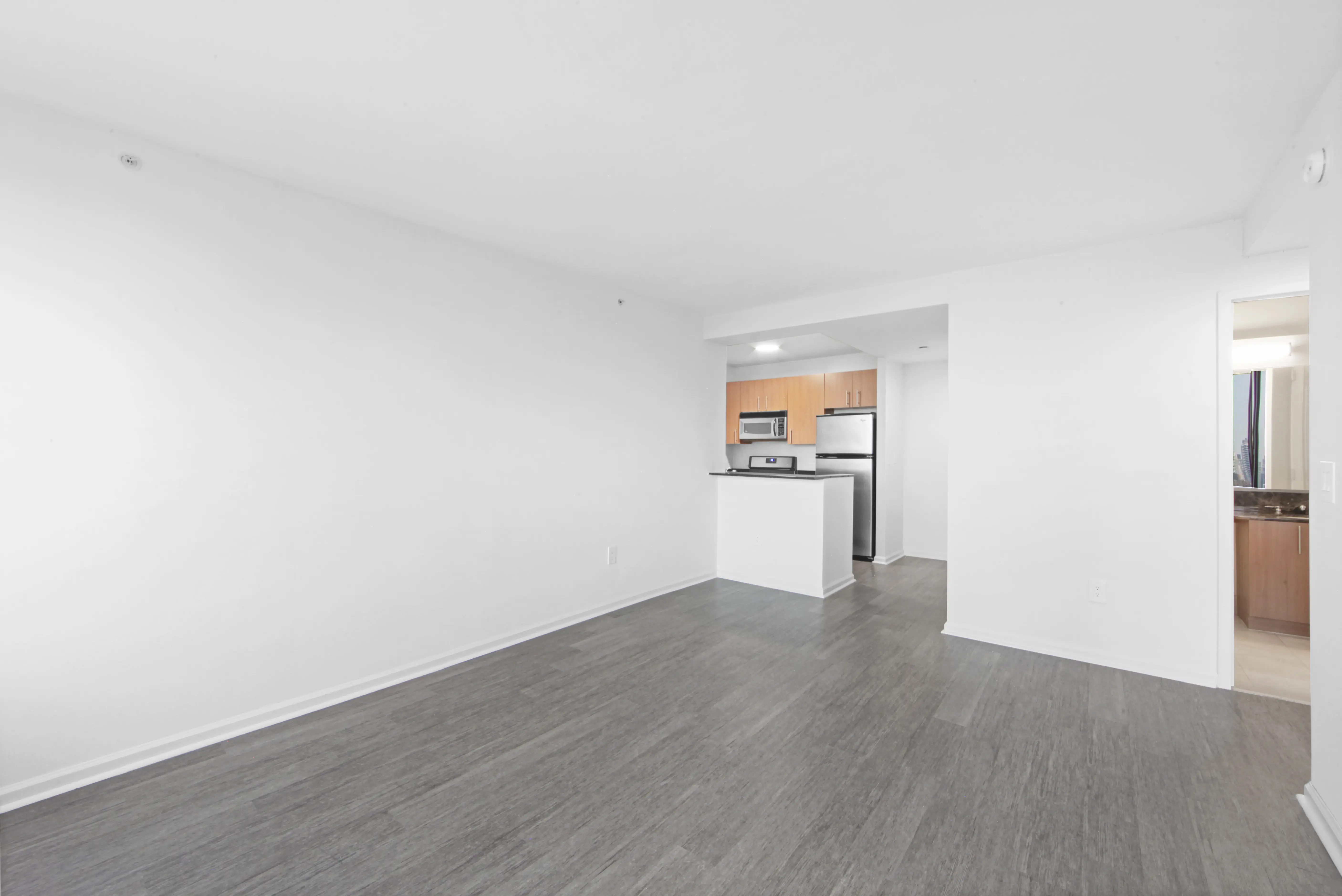 A vacant room with polished hardwood floors and clean white walls, offering a minimalist and open feel.