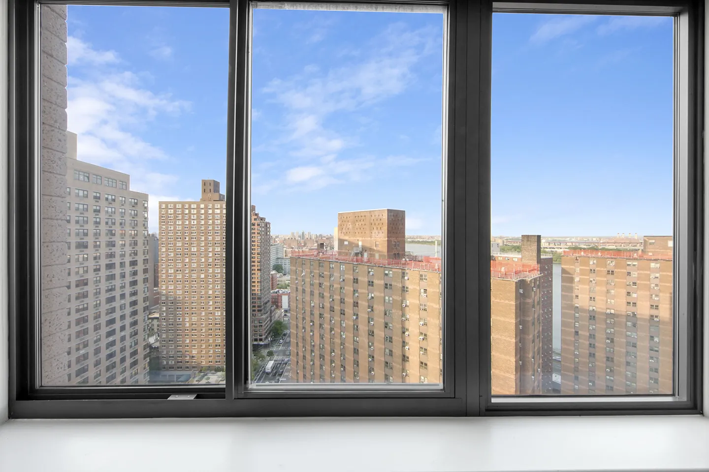 A large window offering a scenic view of the city, highlighting its architecture and urban life.