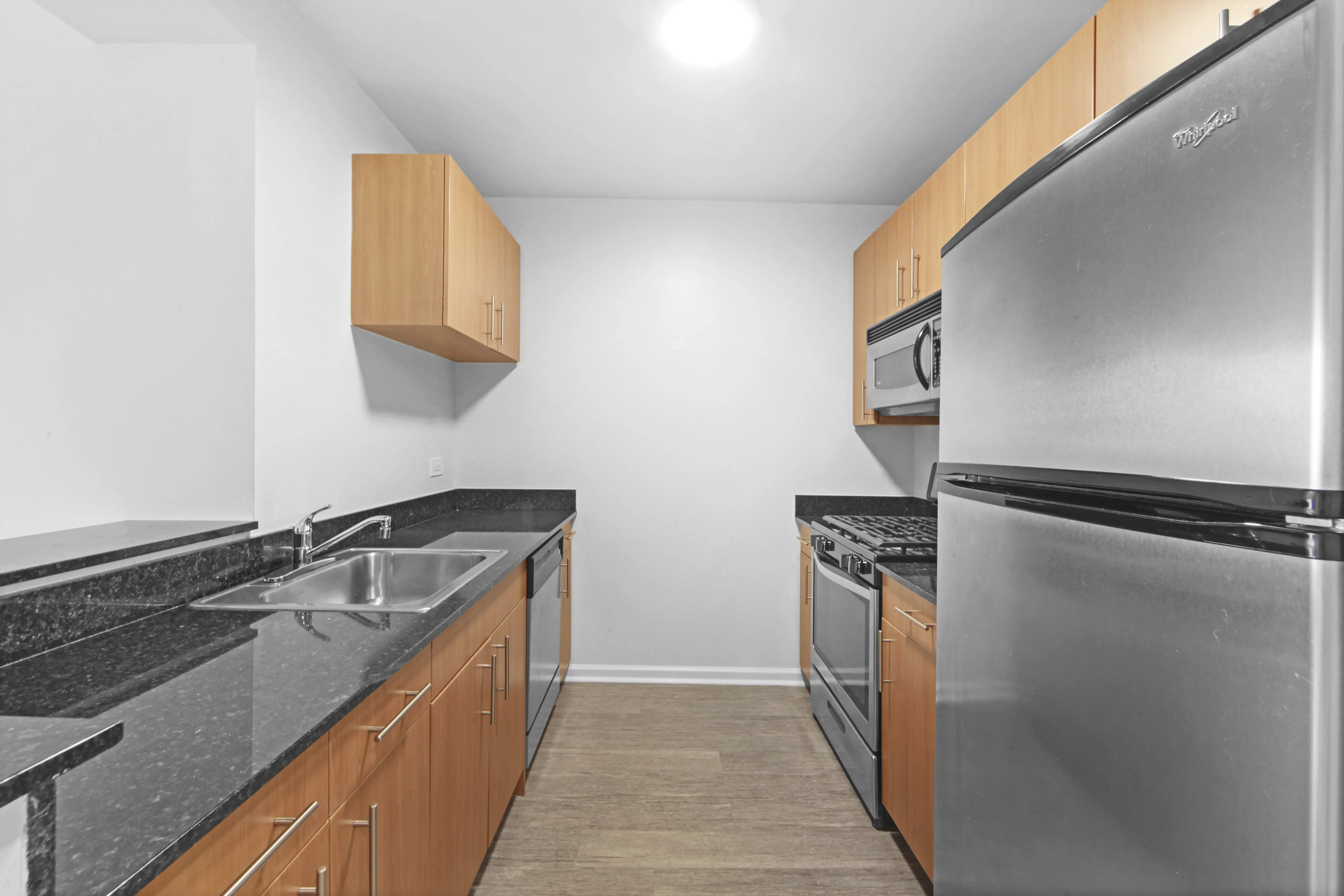 A modern kitchen featuring stainless steel appliances and warm wood cabinets, creating a stylish and functional space.