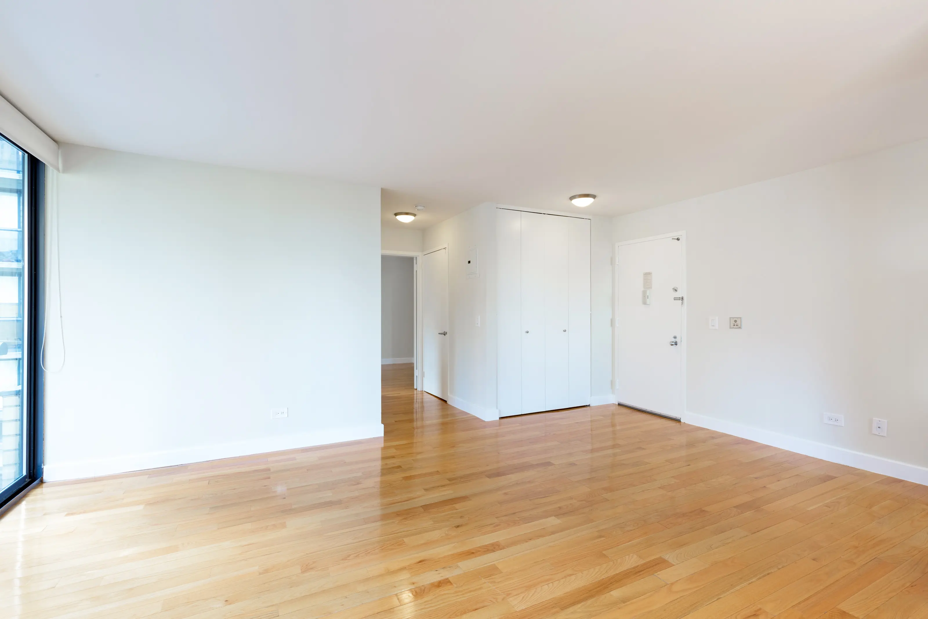 An unoccupied room showcasing hardwood flooring and white walls, emphasizing simplicity and openness.
