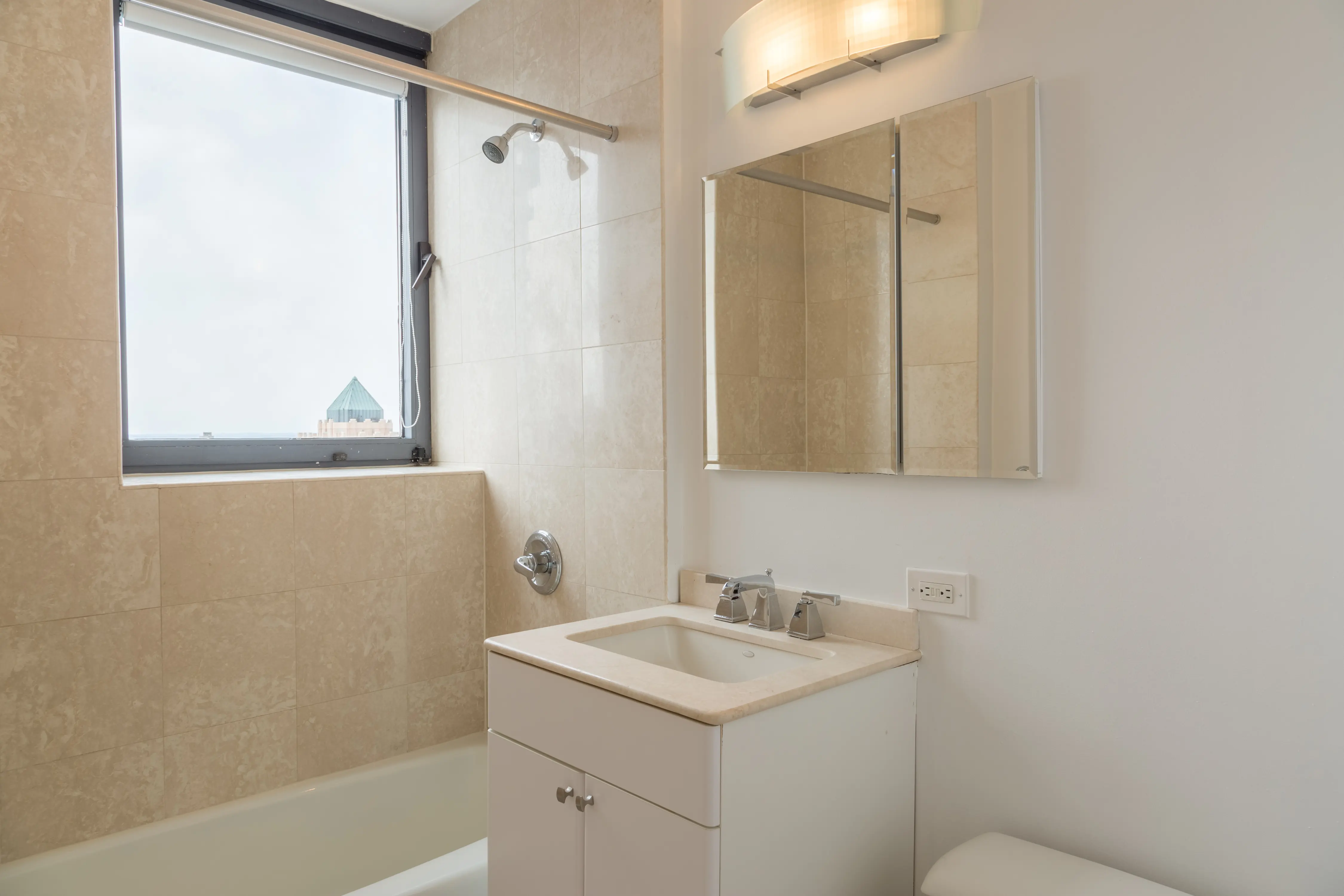 A bathroom featuring a sink, toilet, and a window allowing natural light to enter the space.