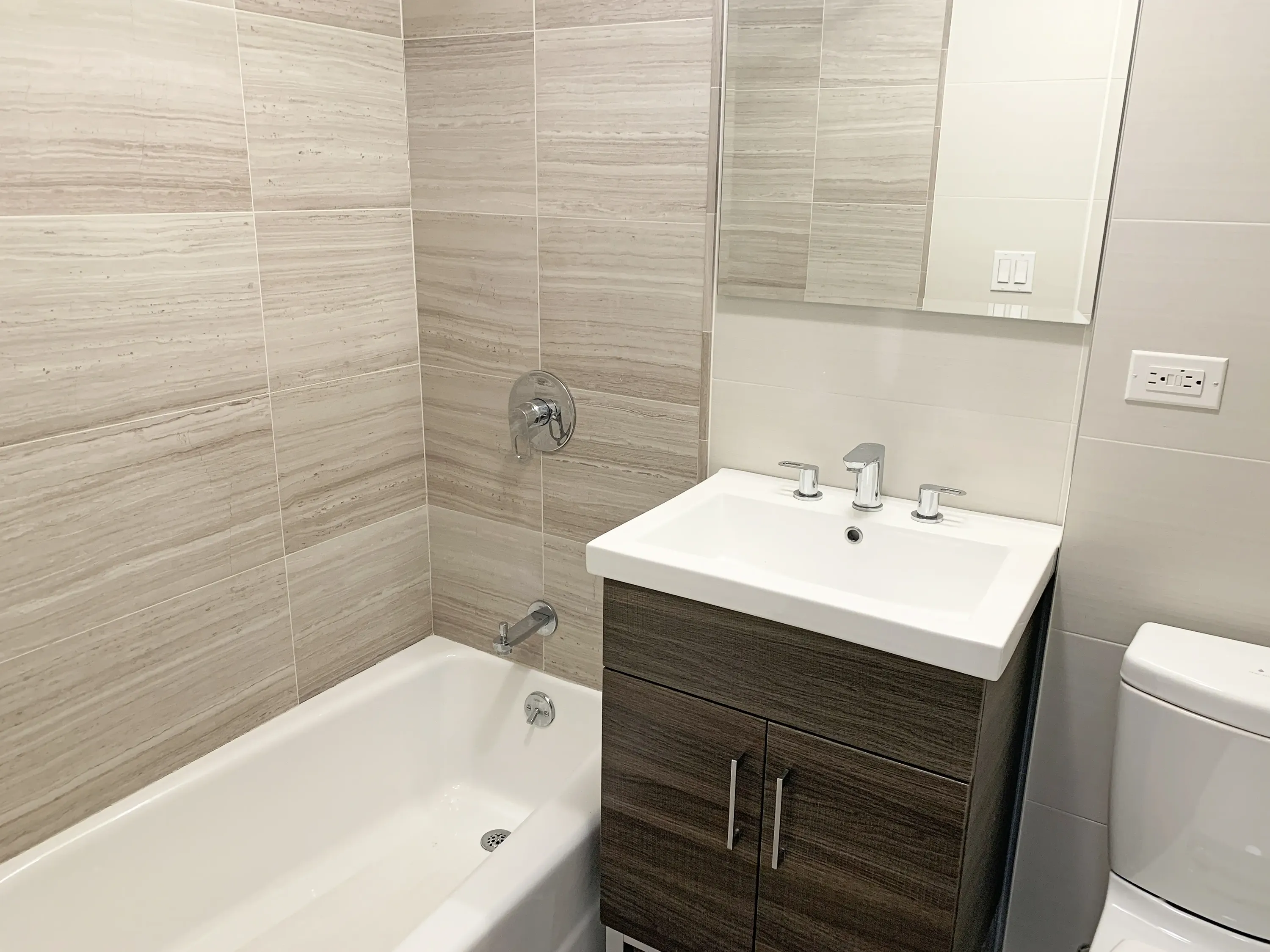 Interior view of a bathroom with a toilet, sink, and bathtub, showcasing a functional and tidy space.