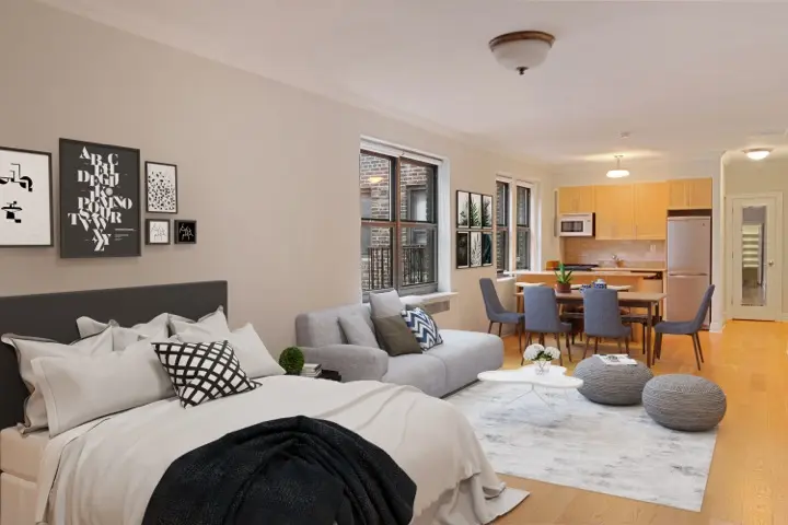 A clean, tidy apartment featuring a bed, couch, and kitchen area, showcasing a cozy and organized living space.