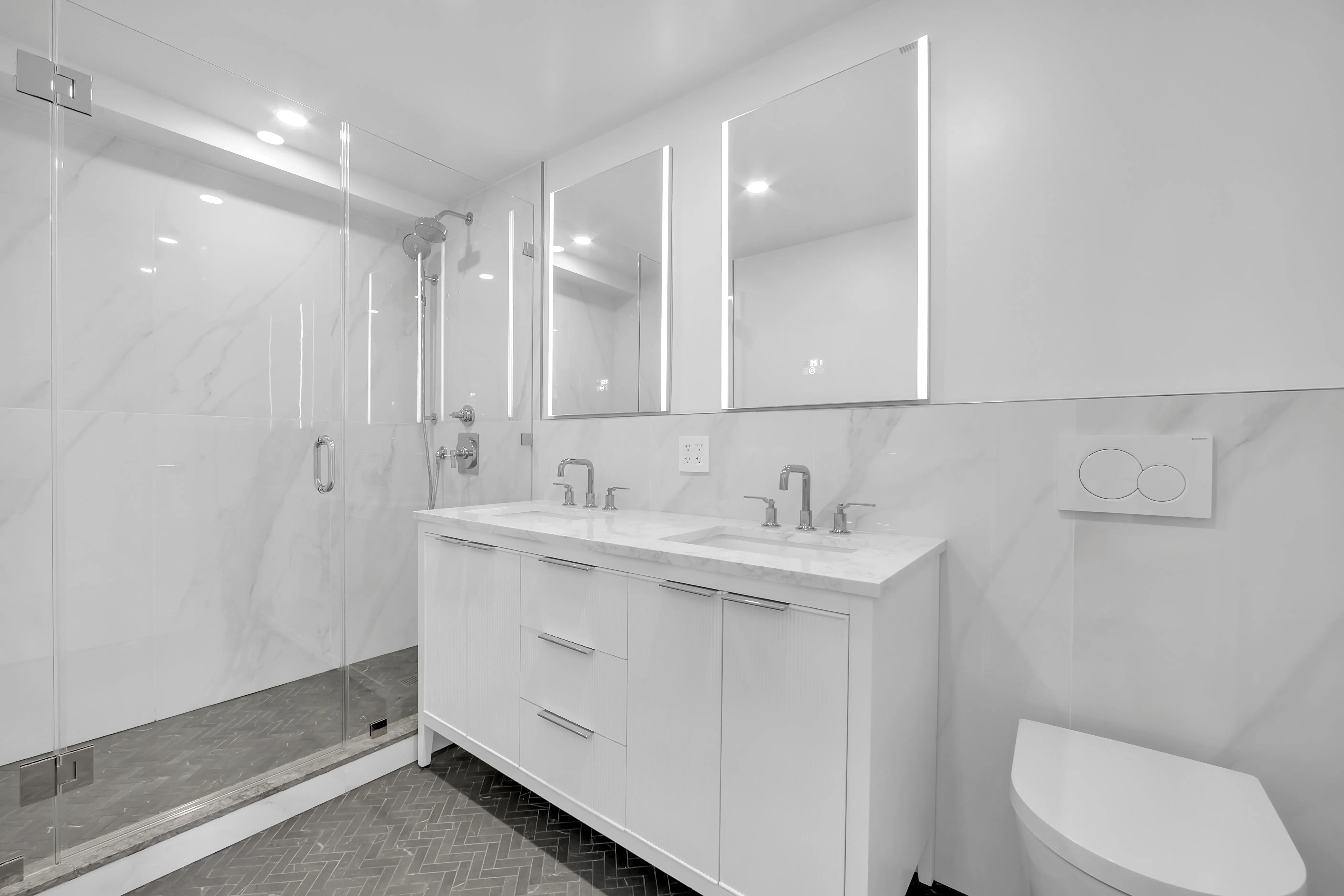 A luxurious bathroom featuring elegant white marble walls and flooring, creating a bright and sophisticated atmosphere.