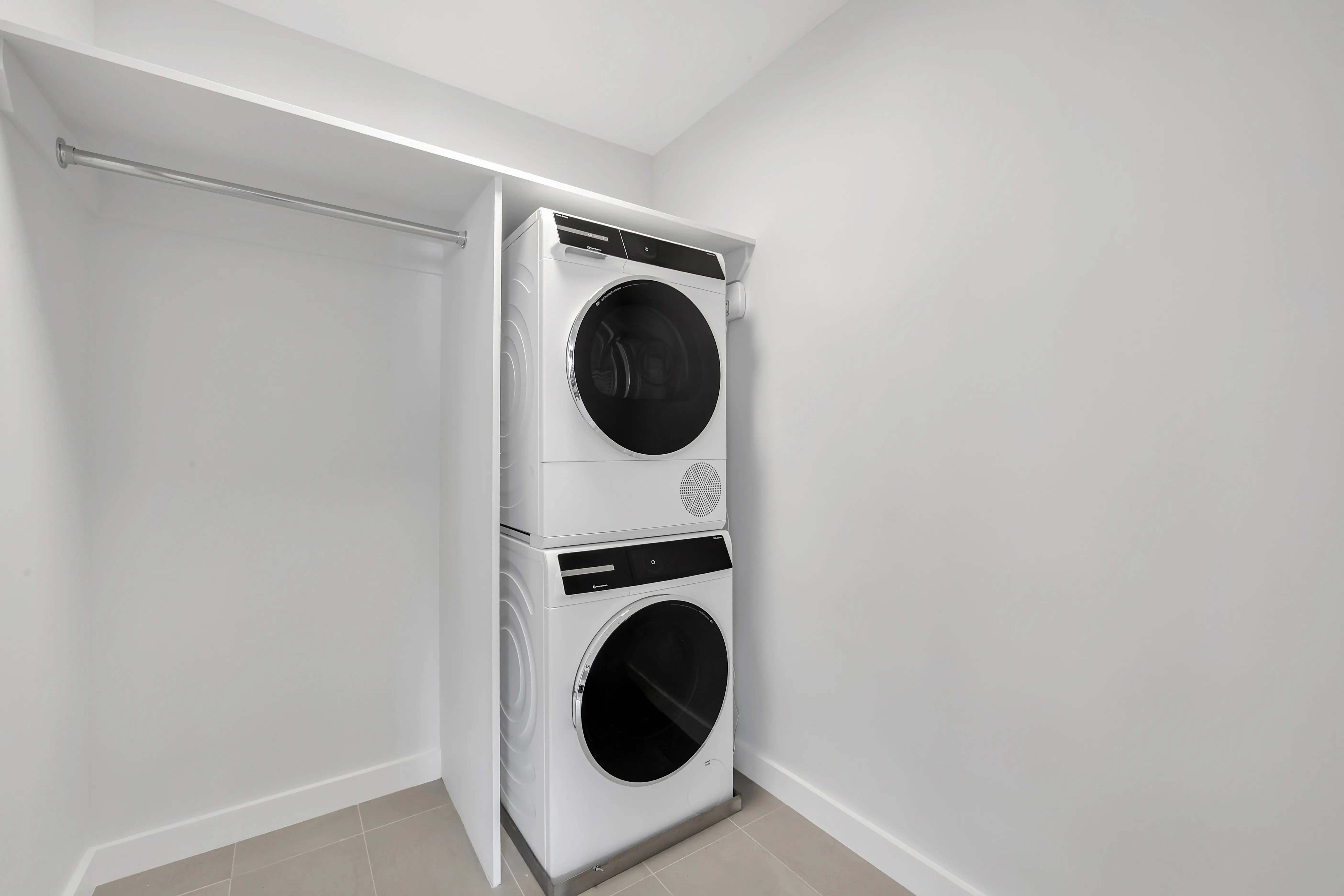 A functional laundry room equipped with a washer and dryer, surrounded by storage shelves and laundry essentials.
