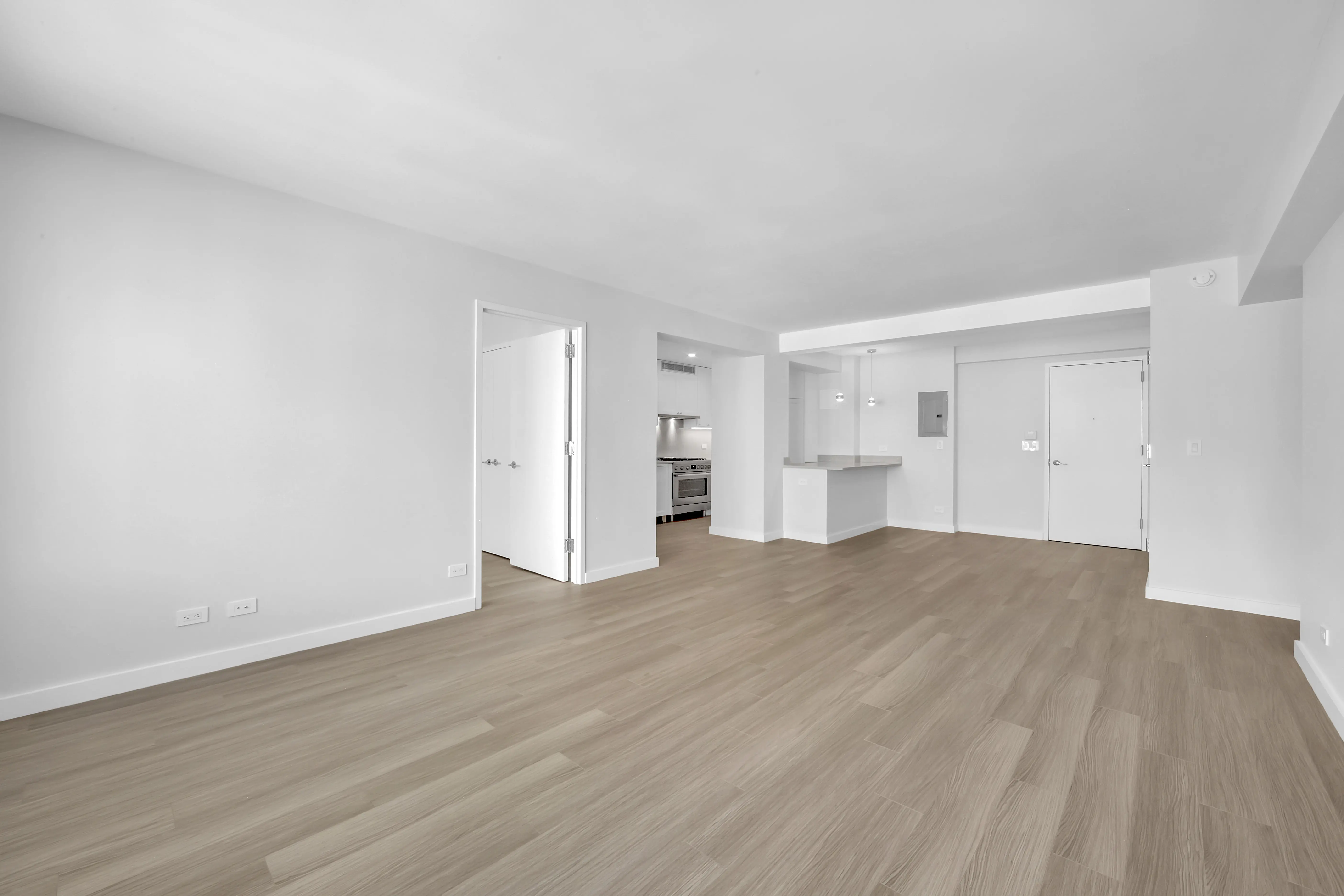 An empty room featuring hardwood floors and white walls, creating a bright and spacious atmosphere.