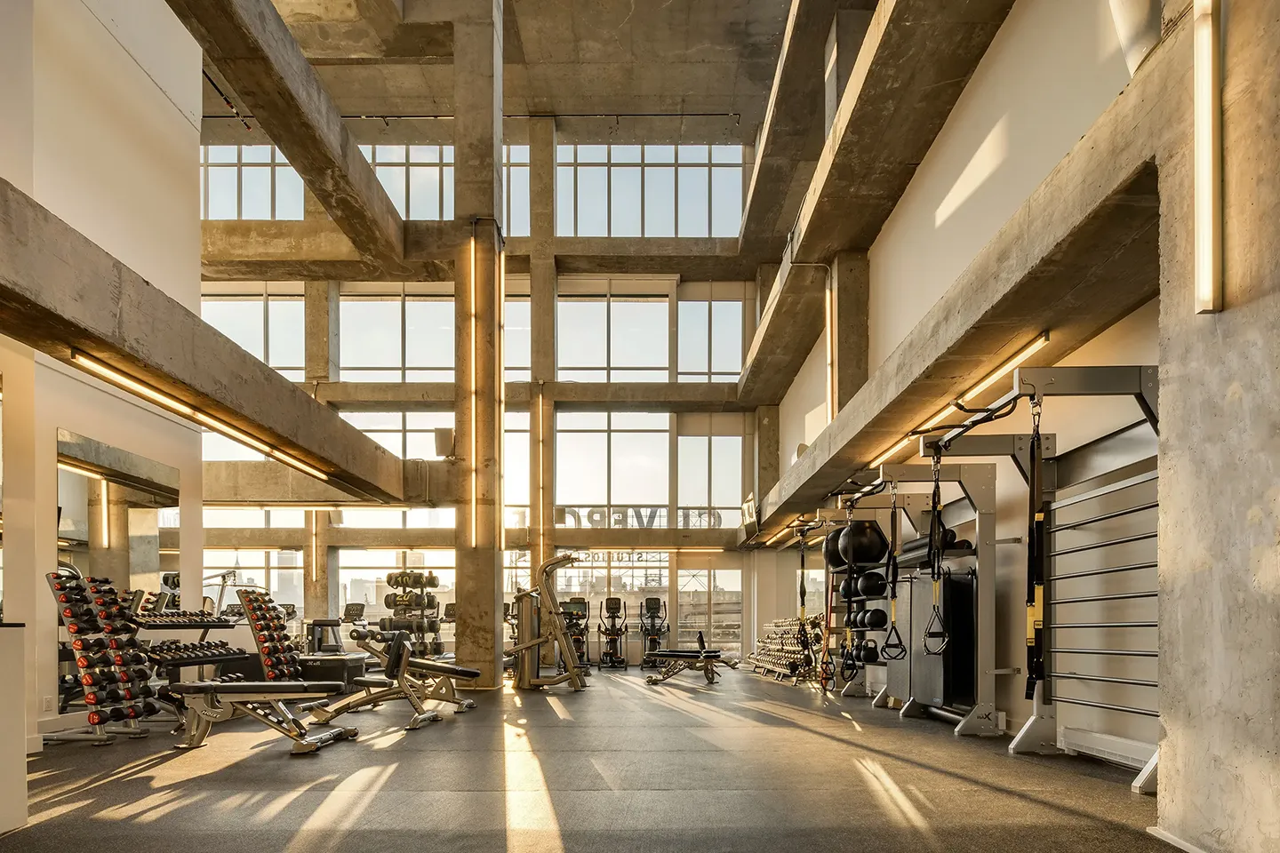 A spacious gym featuring various weights and exercise machines arranged throughout the large room.