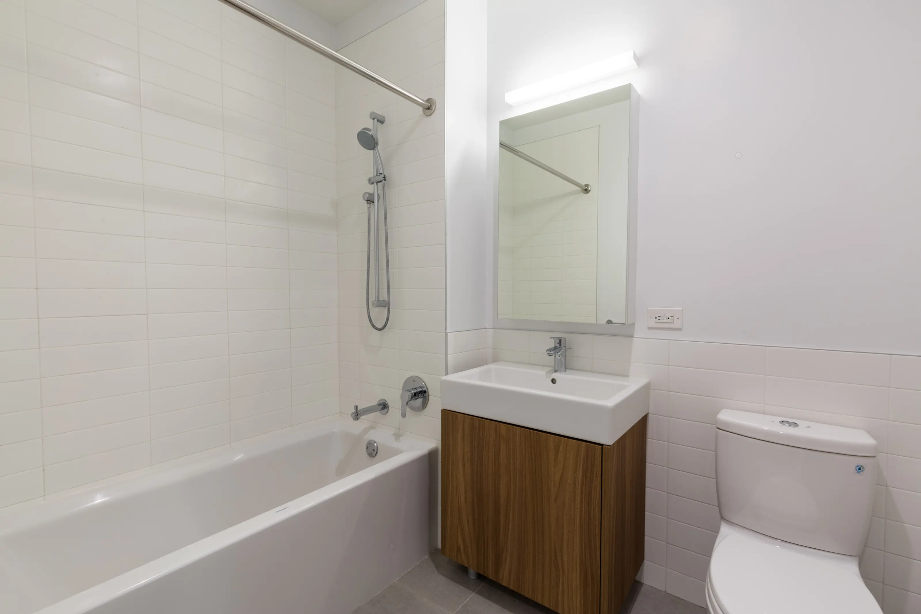 A bathroom featuring a toilet, sink, and bathtub arranged in a clean and modern layout.