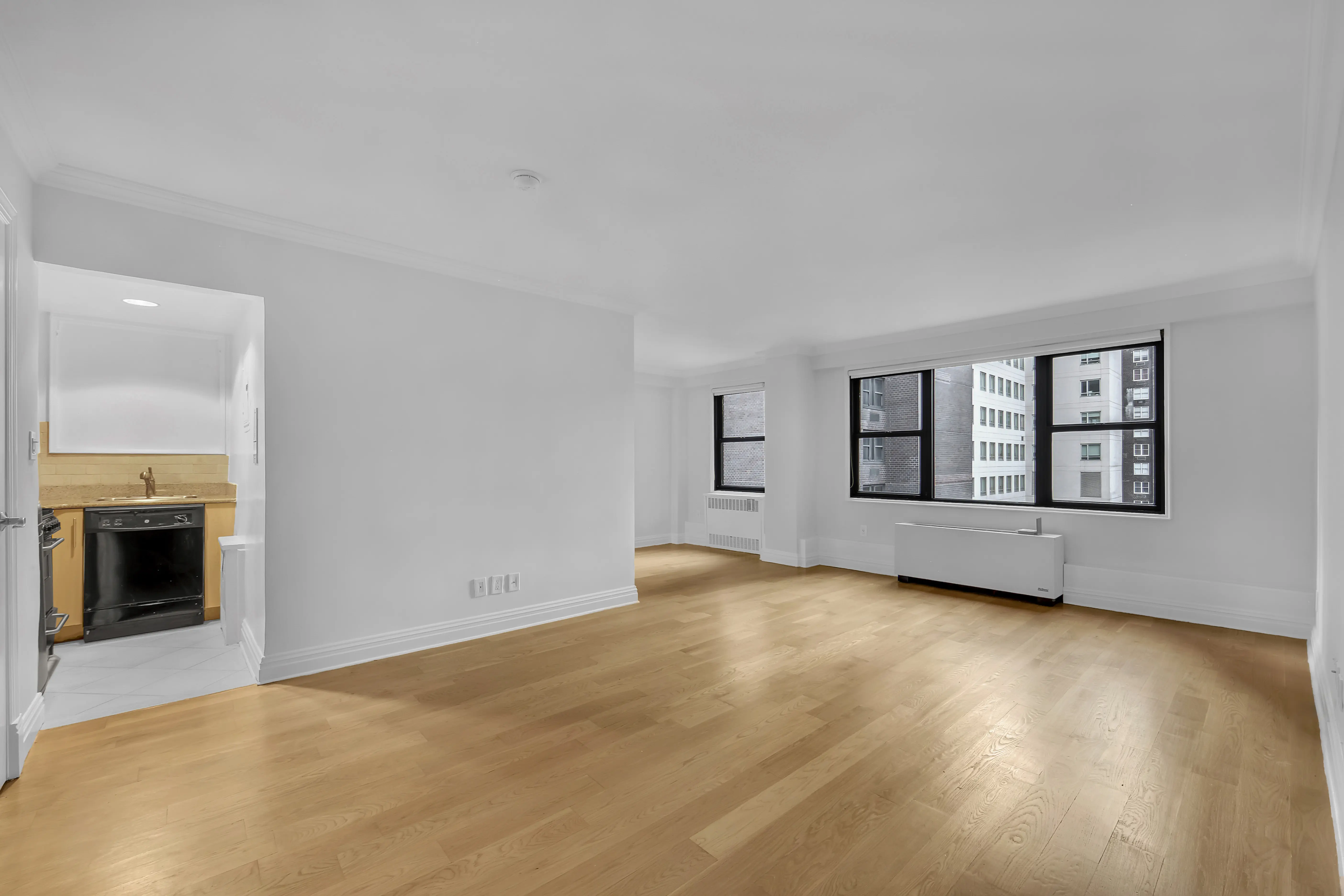 An empty room featuring hardwood floors and white walls, creating a bright and spacious atmosphere.