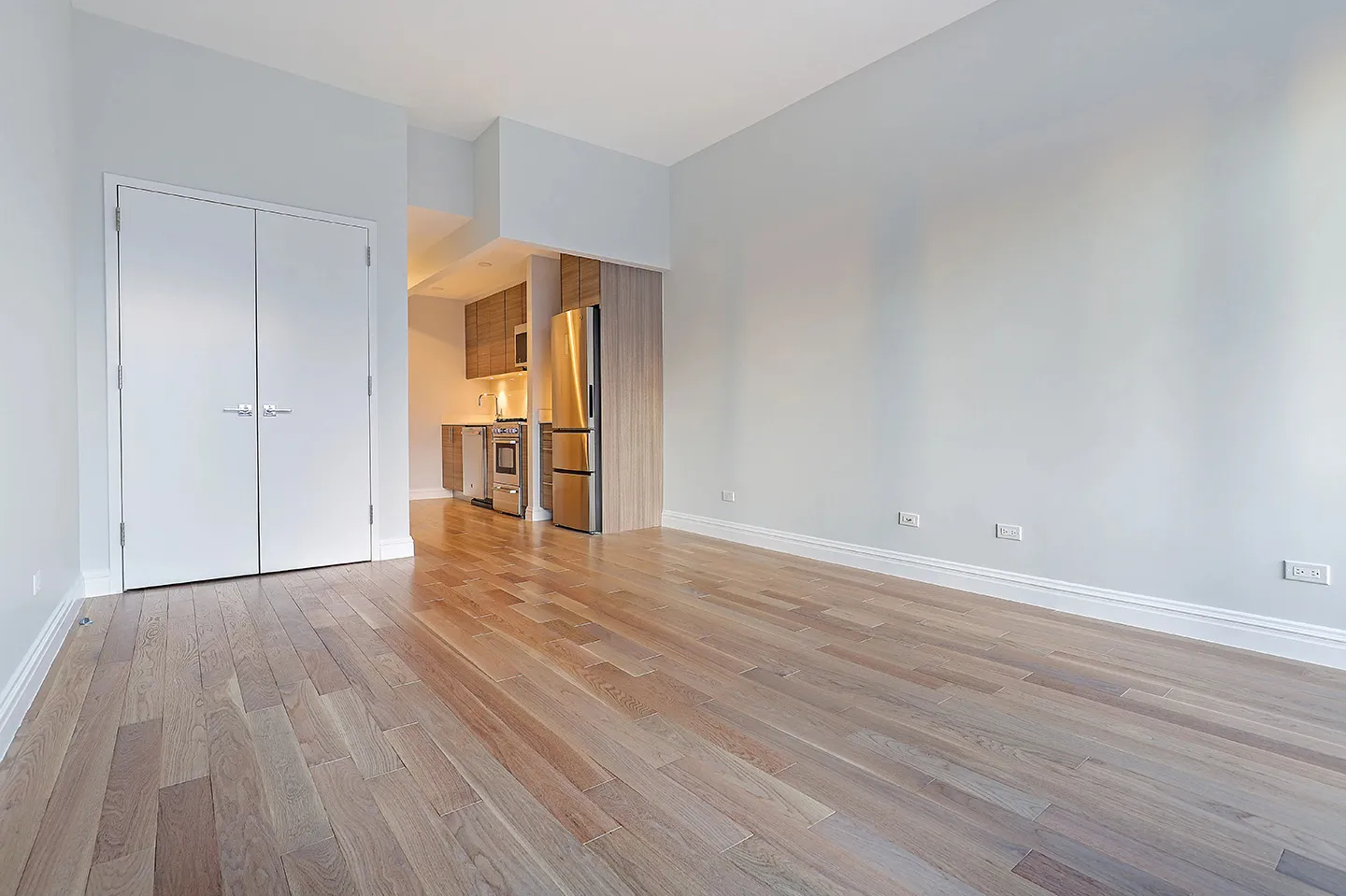 An unoccupied room showcasing hardwood flooring and white walls, emphasizing simplicity and openness.