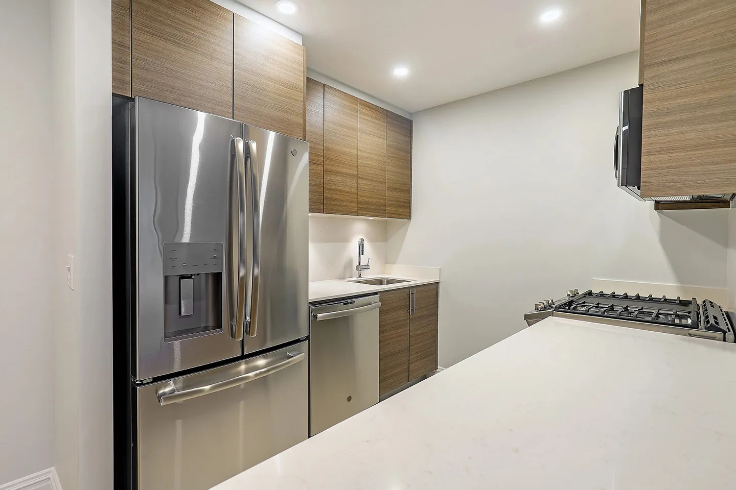 A contemporary kitchen showcasing sleek stainless steel appliances paired with elegant wood cabinets for a warm ambiance.
