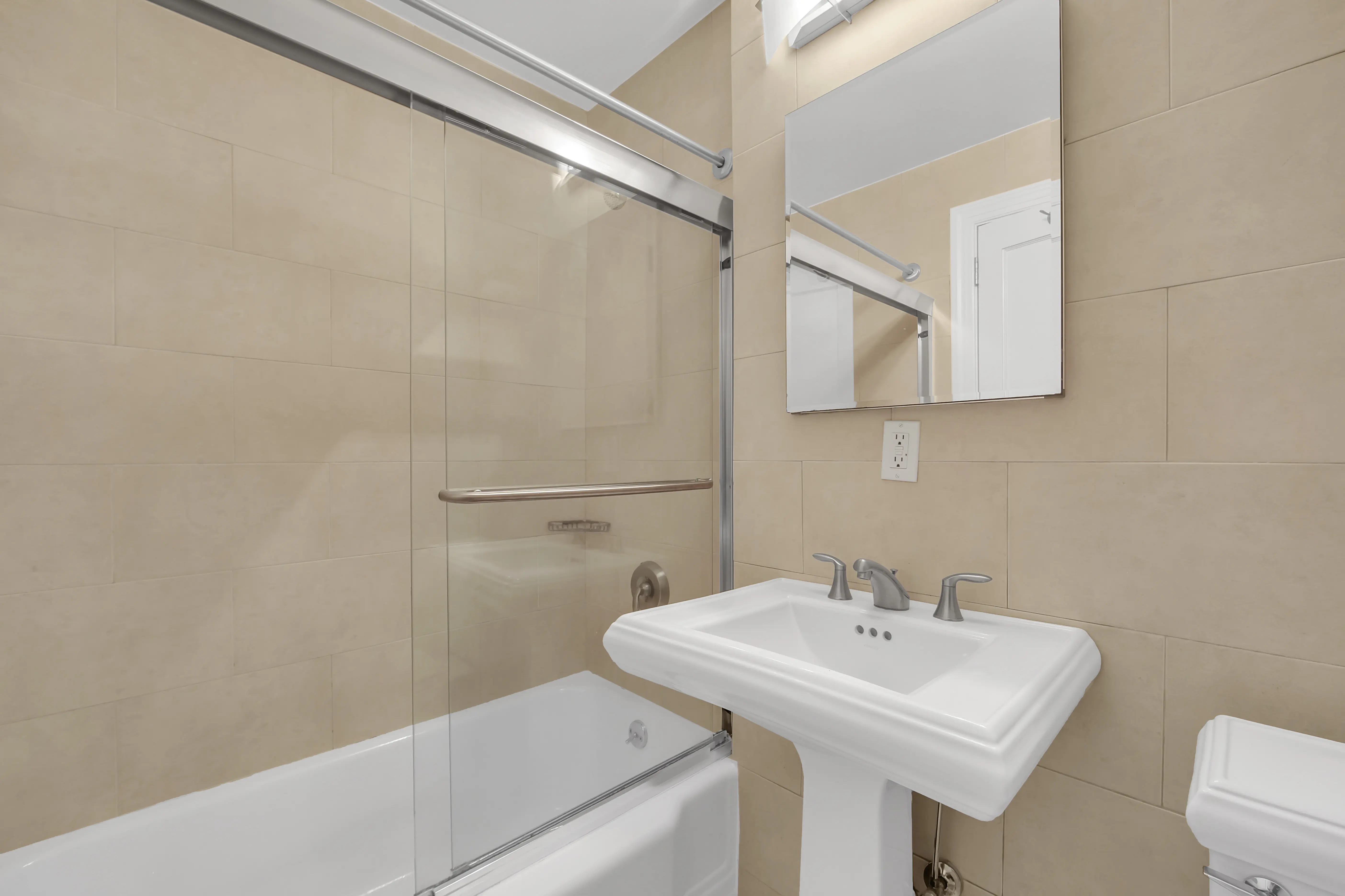 A bathroom featuring a sink, toilet, and shower, designed for functional and efficient use of space.
