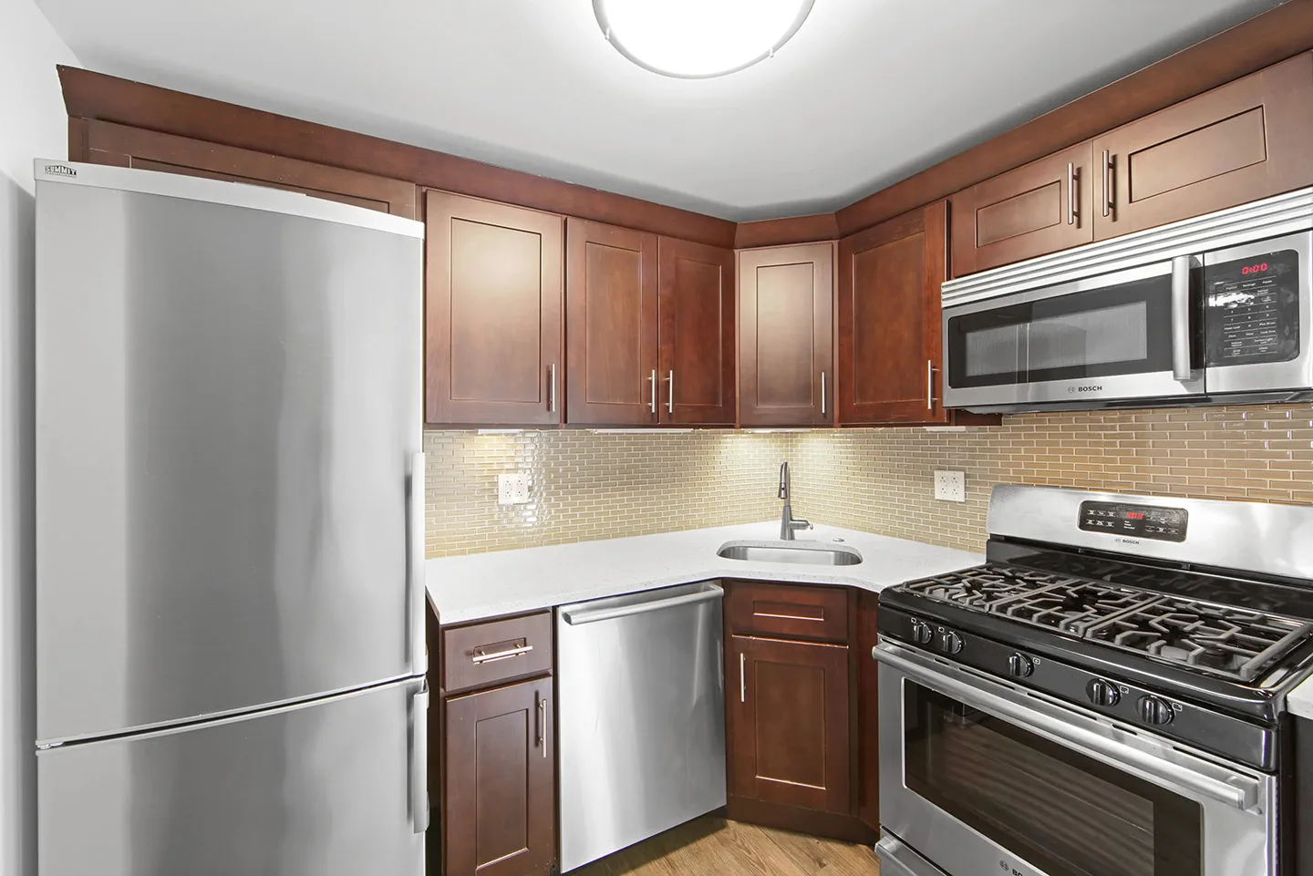 A modern kitchen featuring stainless steel appliances and elegant wooden cabinets.