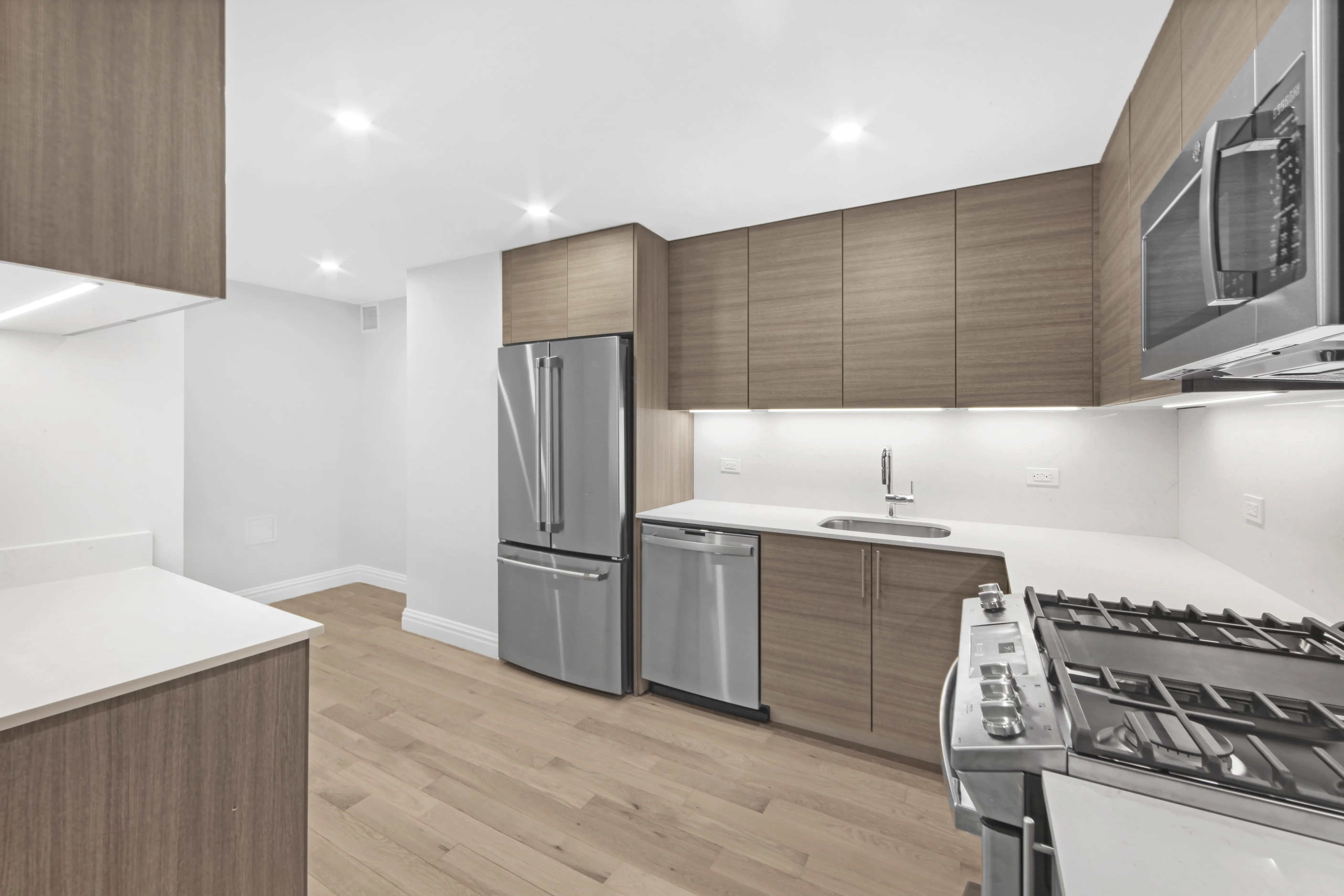 A modern kitchen featuring stainless steel appliances and warm wood cabinets, creating a stylish and functional space.