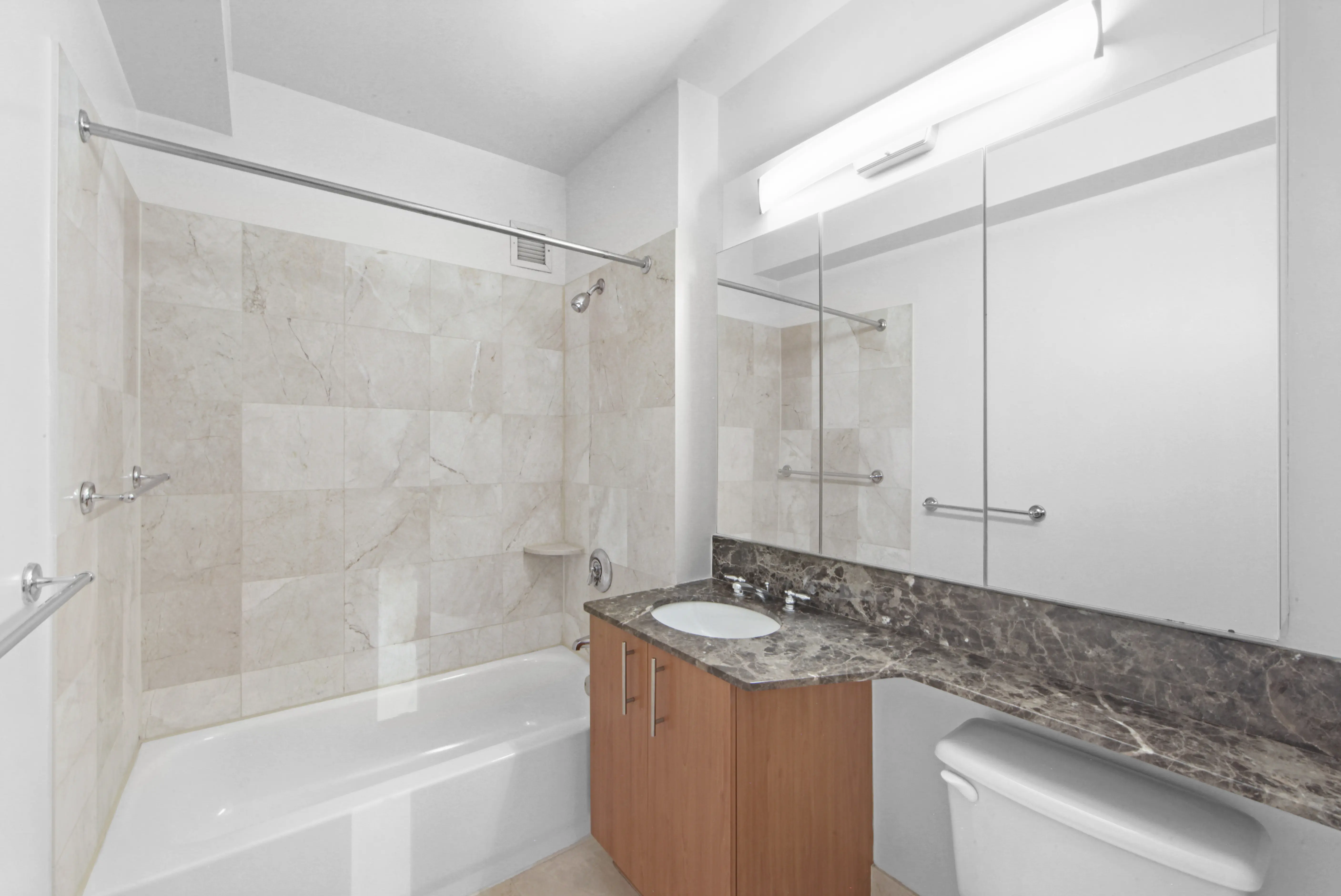 A bathroom featuring a sink, toilet, and shower, designed for functional and efficient use of space.
