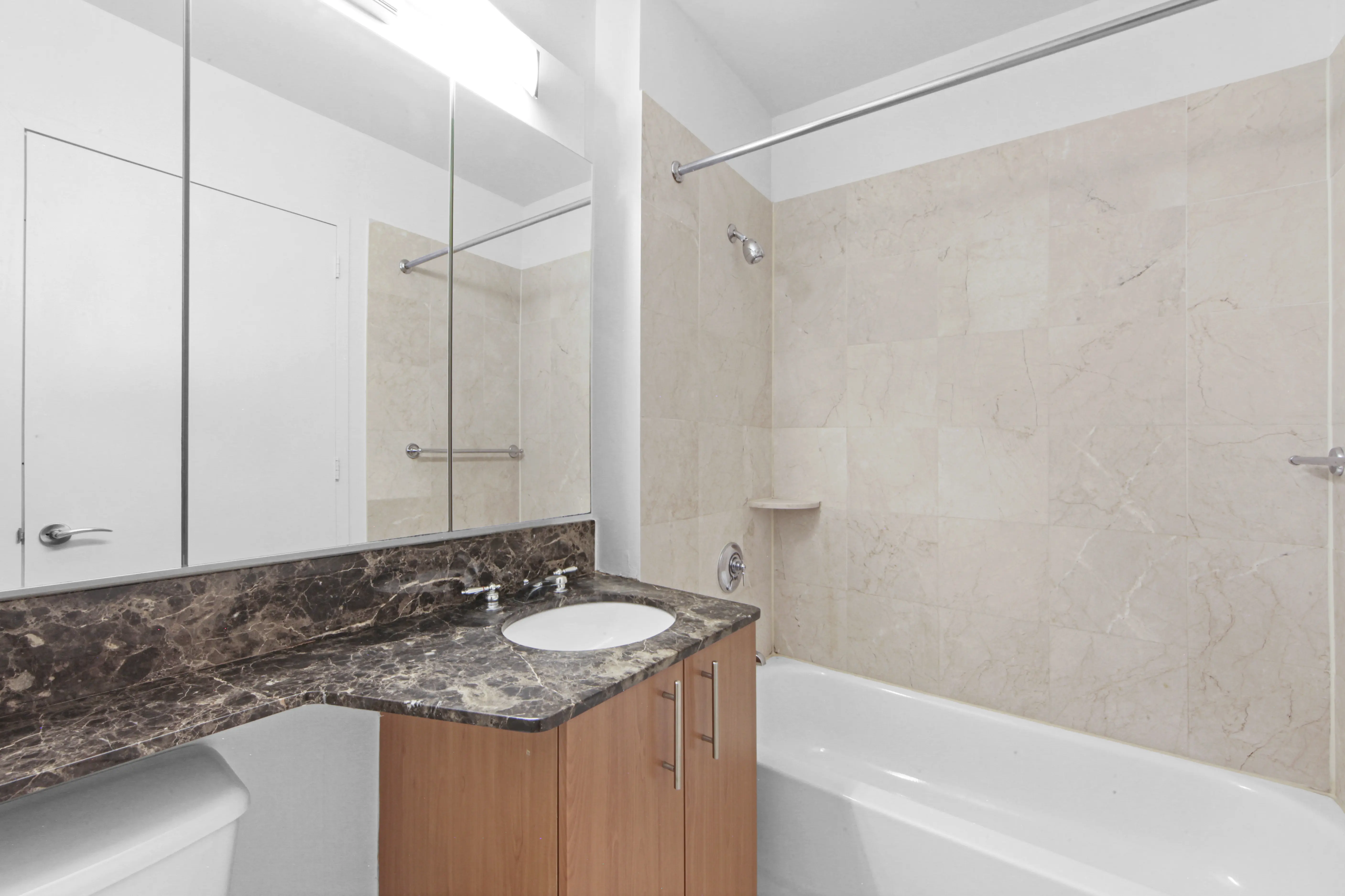 A bathroom featuring a sink, toilet, and shower, designed for functional and efficient use of space.