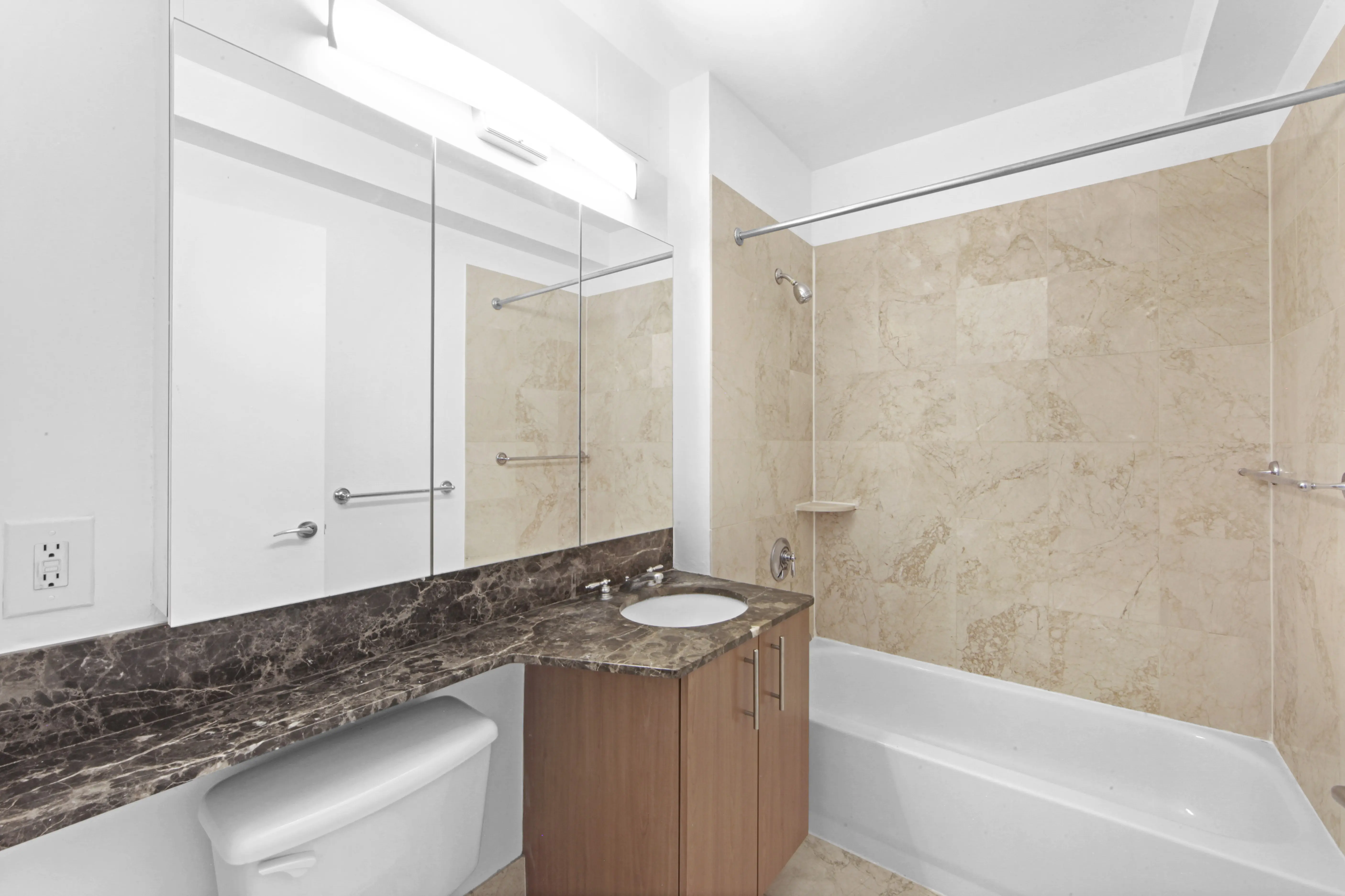 A clean bathroom with a toilet, sink, and shower, showcasing a modern and practical layout.